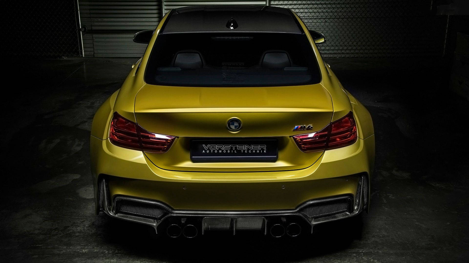 m 桌布 壁紙 — 一輛亮黃色BMW M4在昏暗車庫中的後視圖，戲劇性的燈光突出了其運動型排氣管和尾燈。