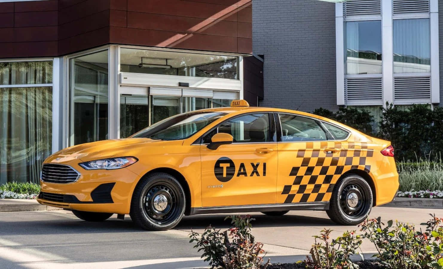 taxi 桌布 壁紙 — 一輛亮黃色帶黑色格子圖案的計程車在陽光明媚的日子停在一棟現代建築外。