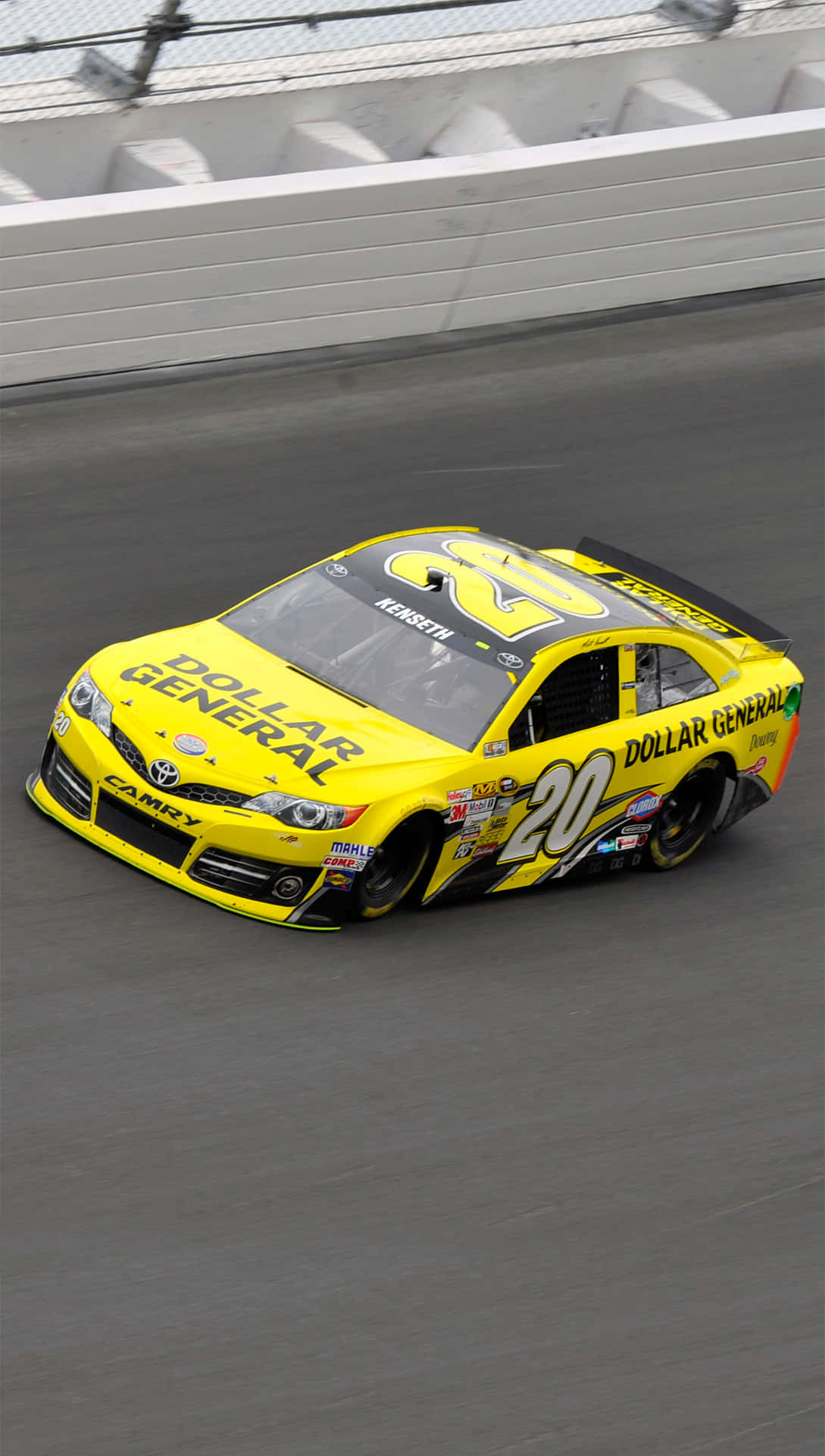桌布 壁紙 — 一輛亮黃色的NASCAR賽車，號碼20，在灰色瀝青賽道上奔馳，賽道兩旁是白色混凝土牆。