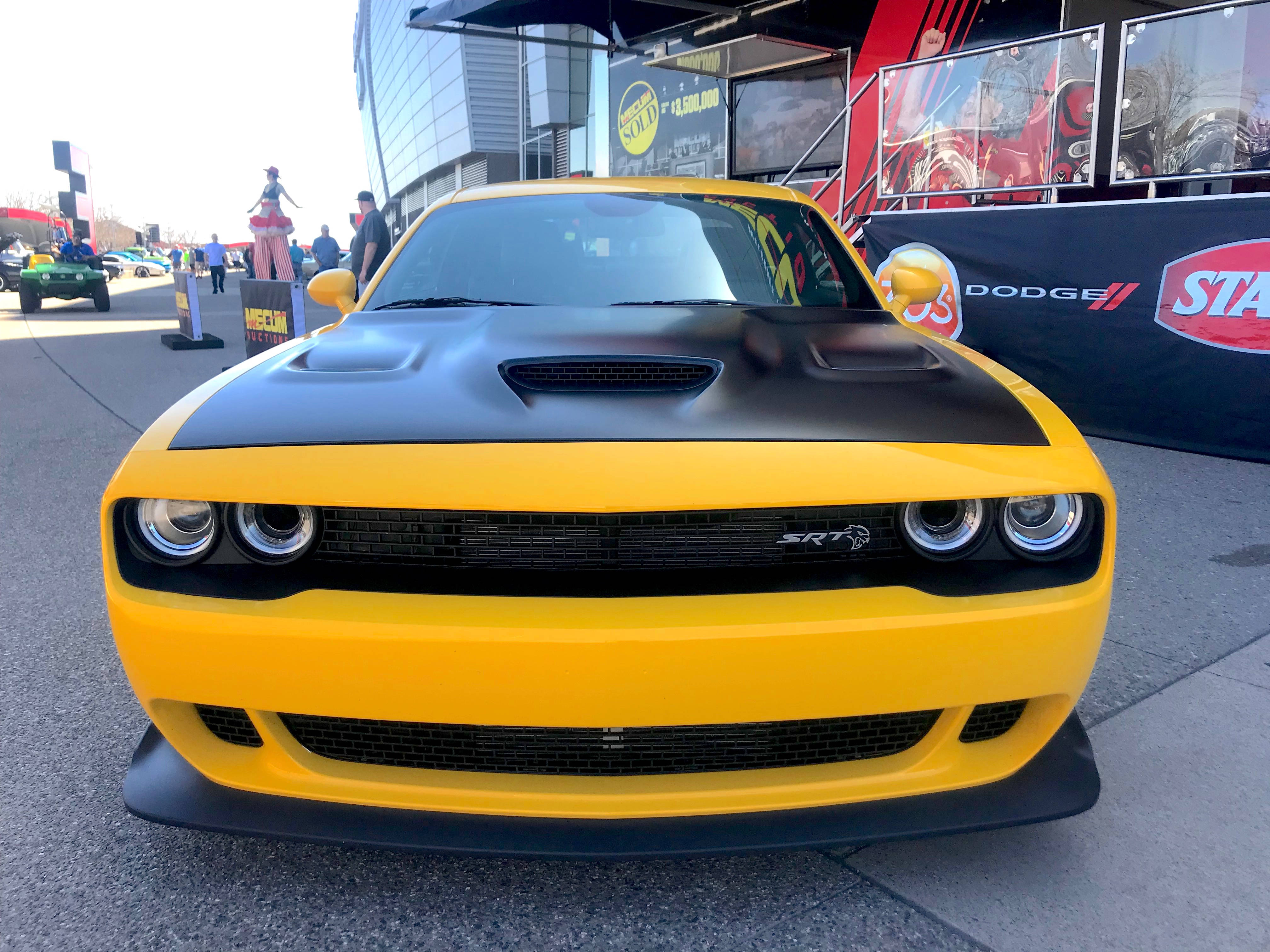 Challenger 桌布 壁紙 — 一輛亮黃色的道奇挑戰者SRT，黑色引擎蓋，在白天戶外車展中格外醒目。