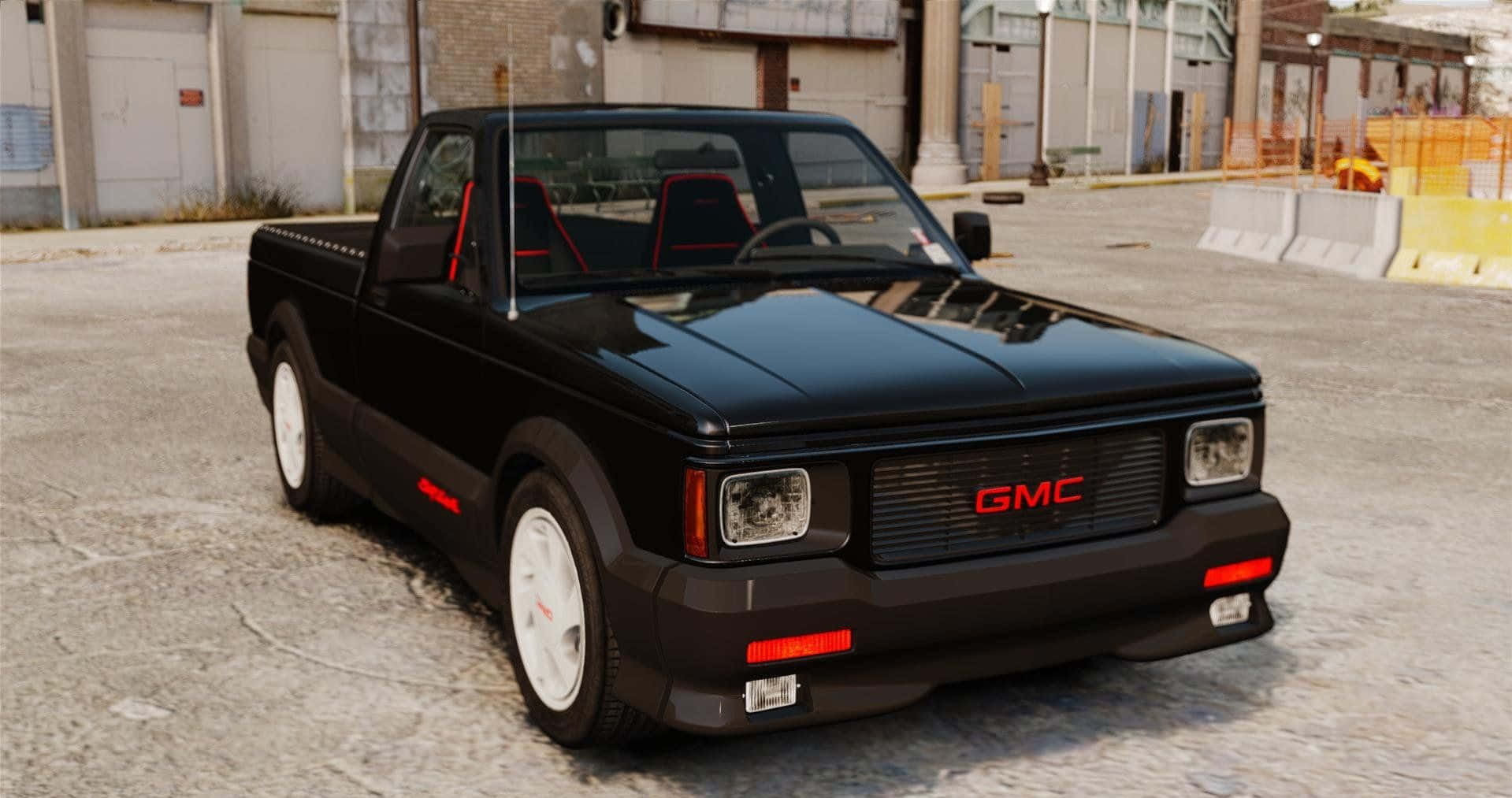 Gmc Syclone 桌布 壁紙 — 一輛亮黑色GMC皮卡車，帶有紅色點綴和白色輪胎，停在工業區。