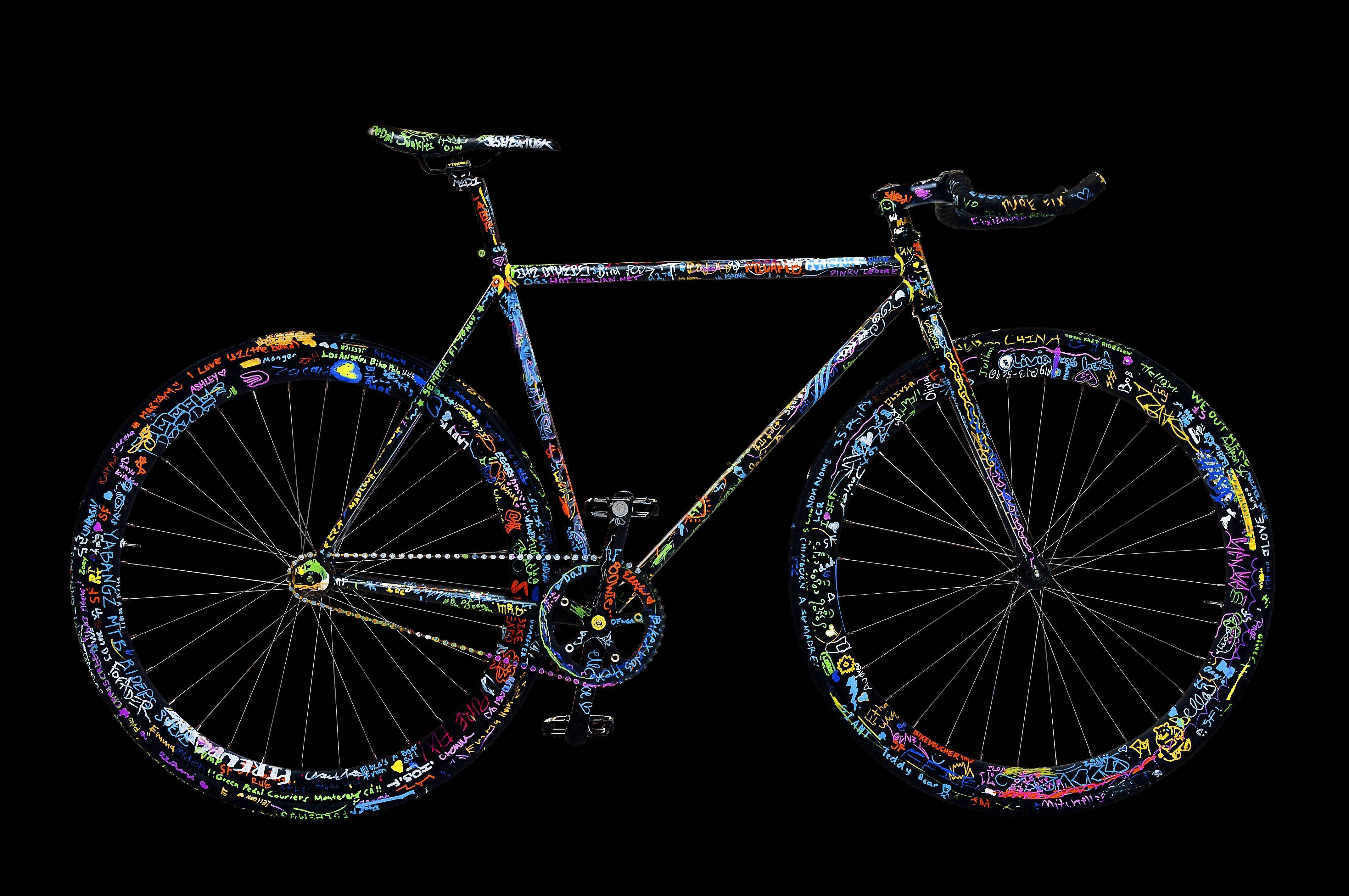 Bicycle 桌布 壁紙 — 一輛佈滿鮮豔塗鴉藝術的自行車，在純黑背景下格外突出。
