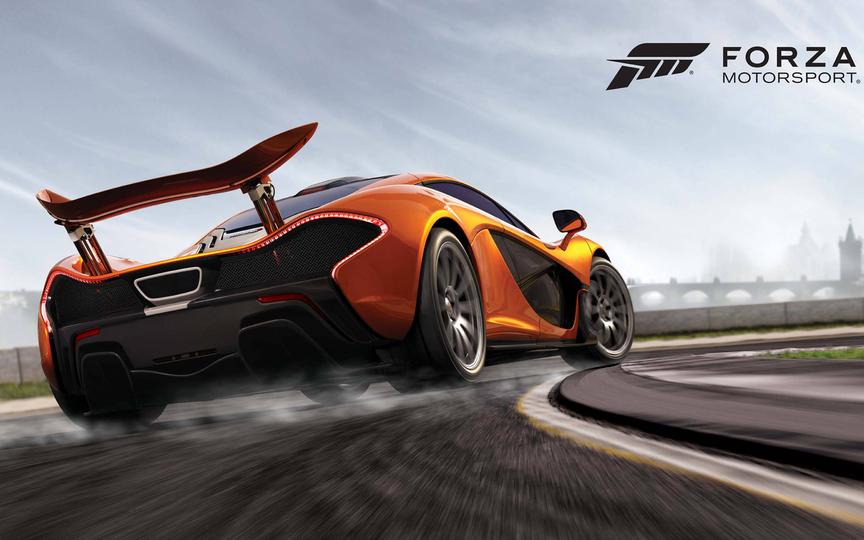 Forza Gaming 桌布 壁紙 — 一輛充滿活力的橙色McLaren跑車在潮濕的賽道上飄移，背景是朦朧的城市天際線。