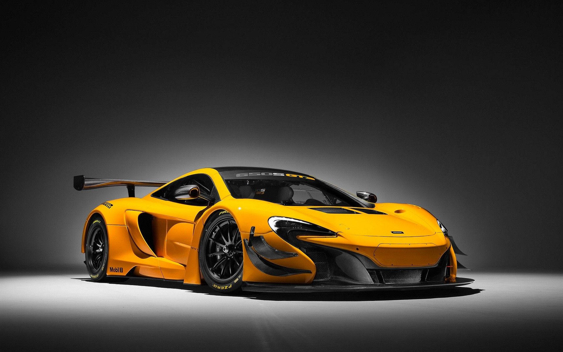 cars 桌布 壁紙 — 一輛充滿活力的橙色McLaren Senna GT賽車，帶有黑色裝飾和大型後尾翼，在深色工作室背景下戲劇性地照明。