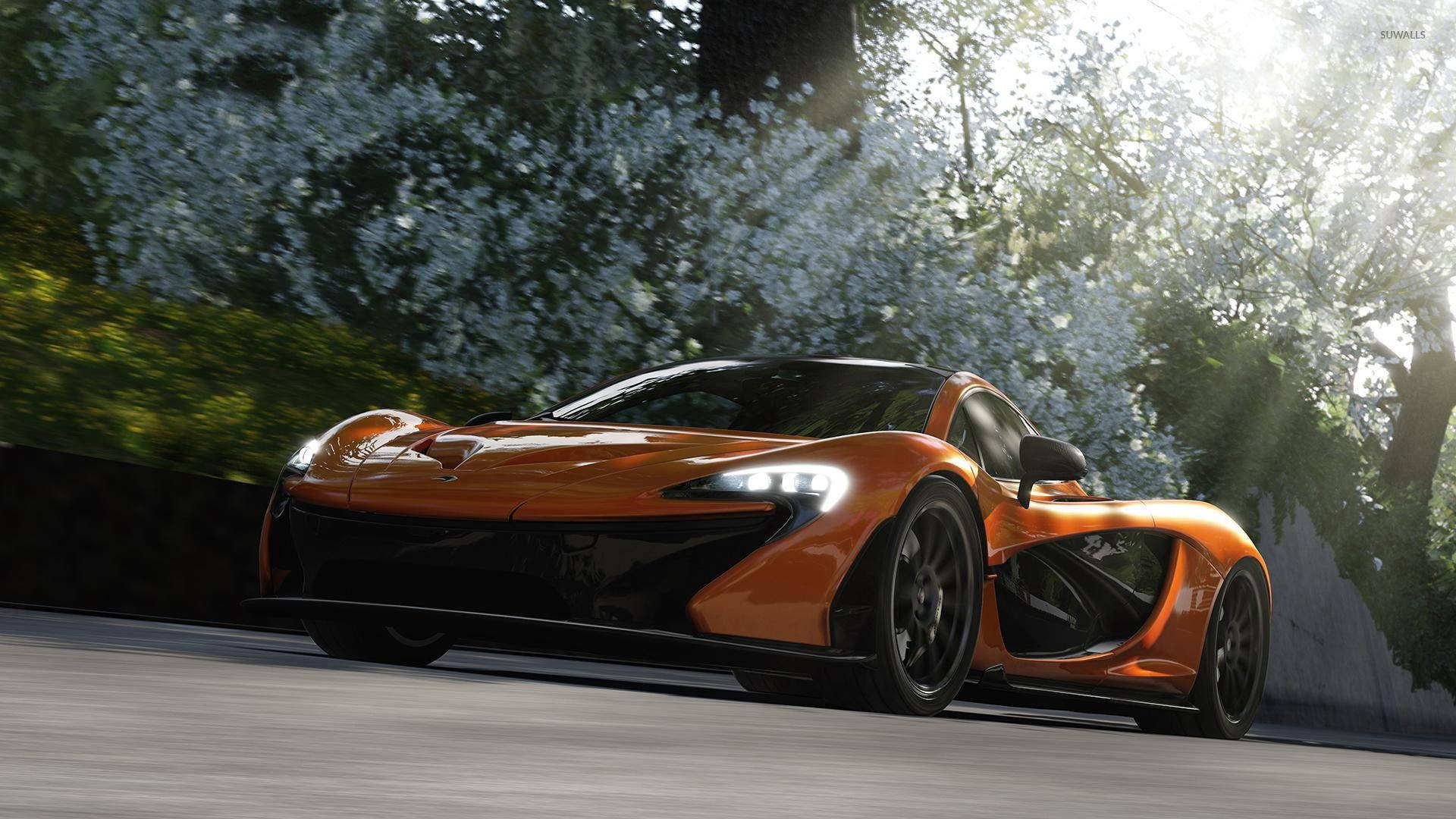 電玩遊戲 桌布 壁紙 — 一輛充滿活力的橙色McLaren P1超級跑車在陽光明媚的道路上奔馳，兩旁是盛開的白色樹木和茂密的綠色植物。