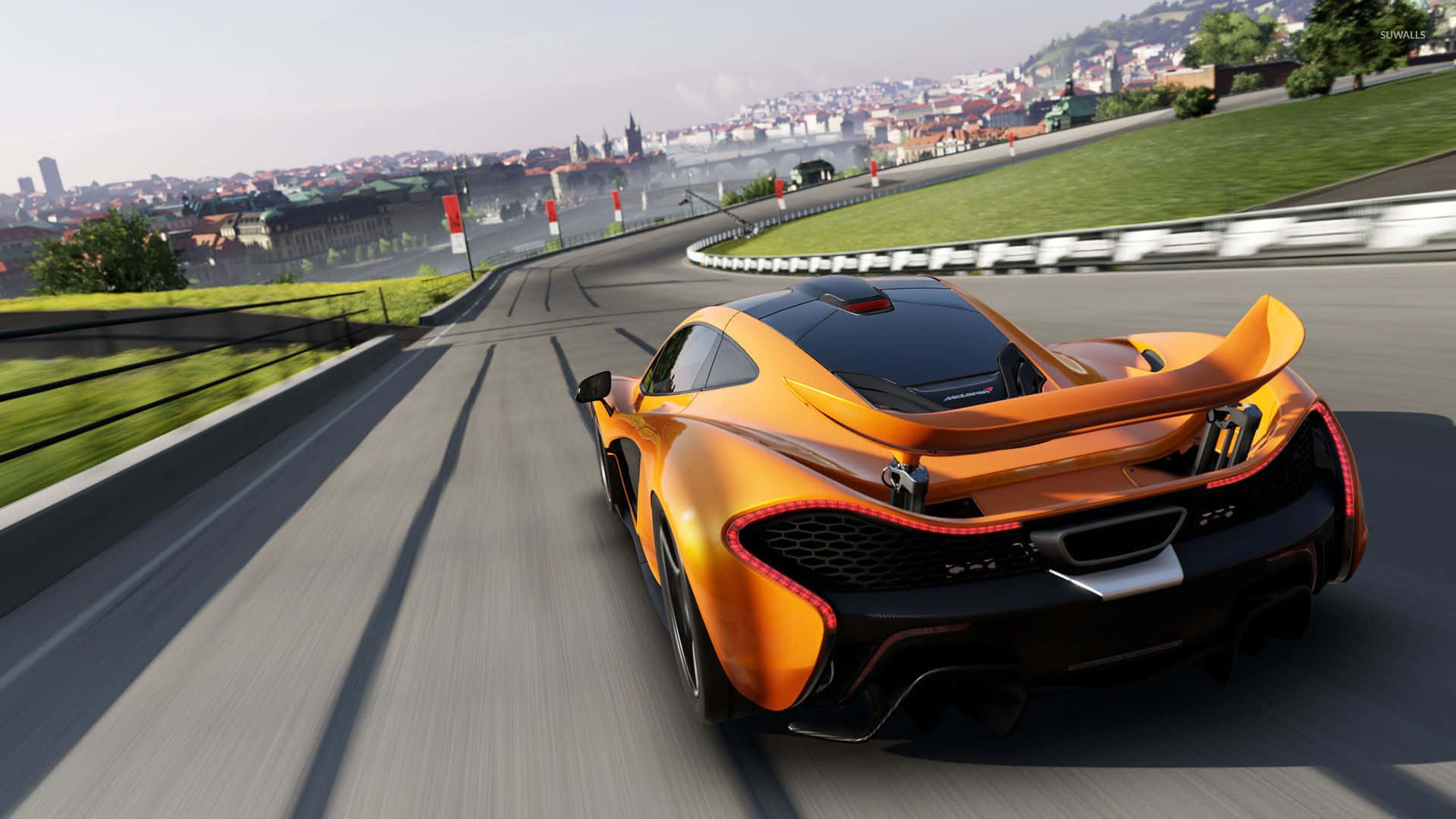電玩遊戲 桌布 壁紙 — 一輛充滿活力的橙色McLaren P1在明亮的日光下沿著蜿蜒的賽道奔馳，背景是城市天際線。