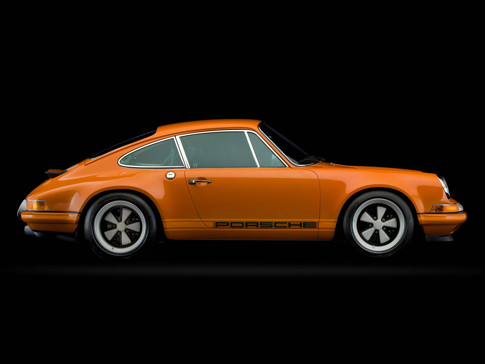 Singer 桌布 壁紙 — 一輛充滿活力的橙色經典保時捷911跑車在純黑色背景上以側面輪廓展示。