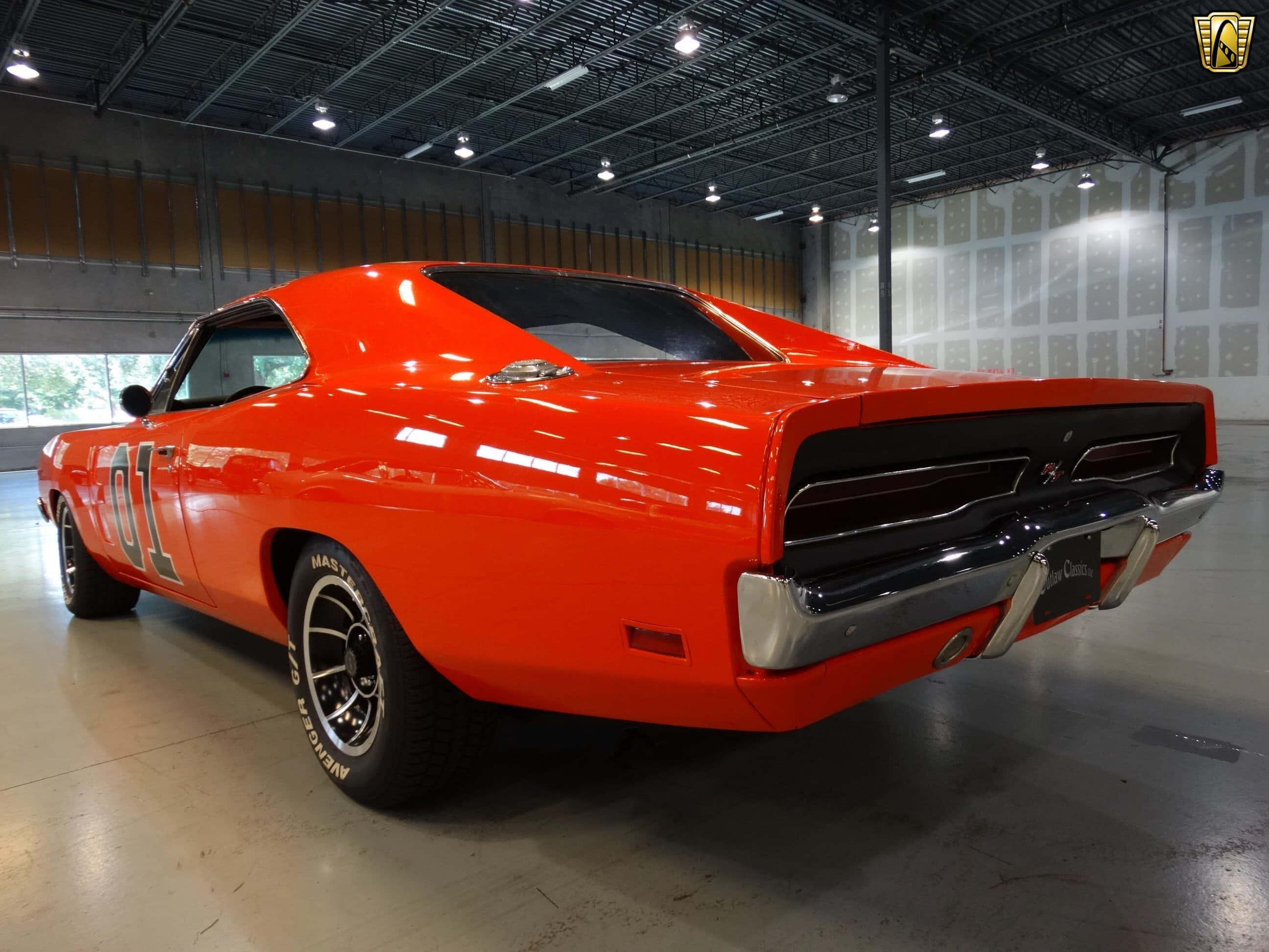 General Lee 車 桌布 壁紙 — 一輛充滿活力的橙色經典肌肉車，帶有「01」賽車貼紙，在明亮的車庫燈光下閃閃發光。