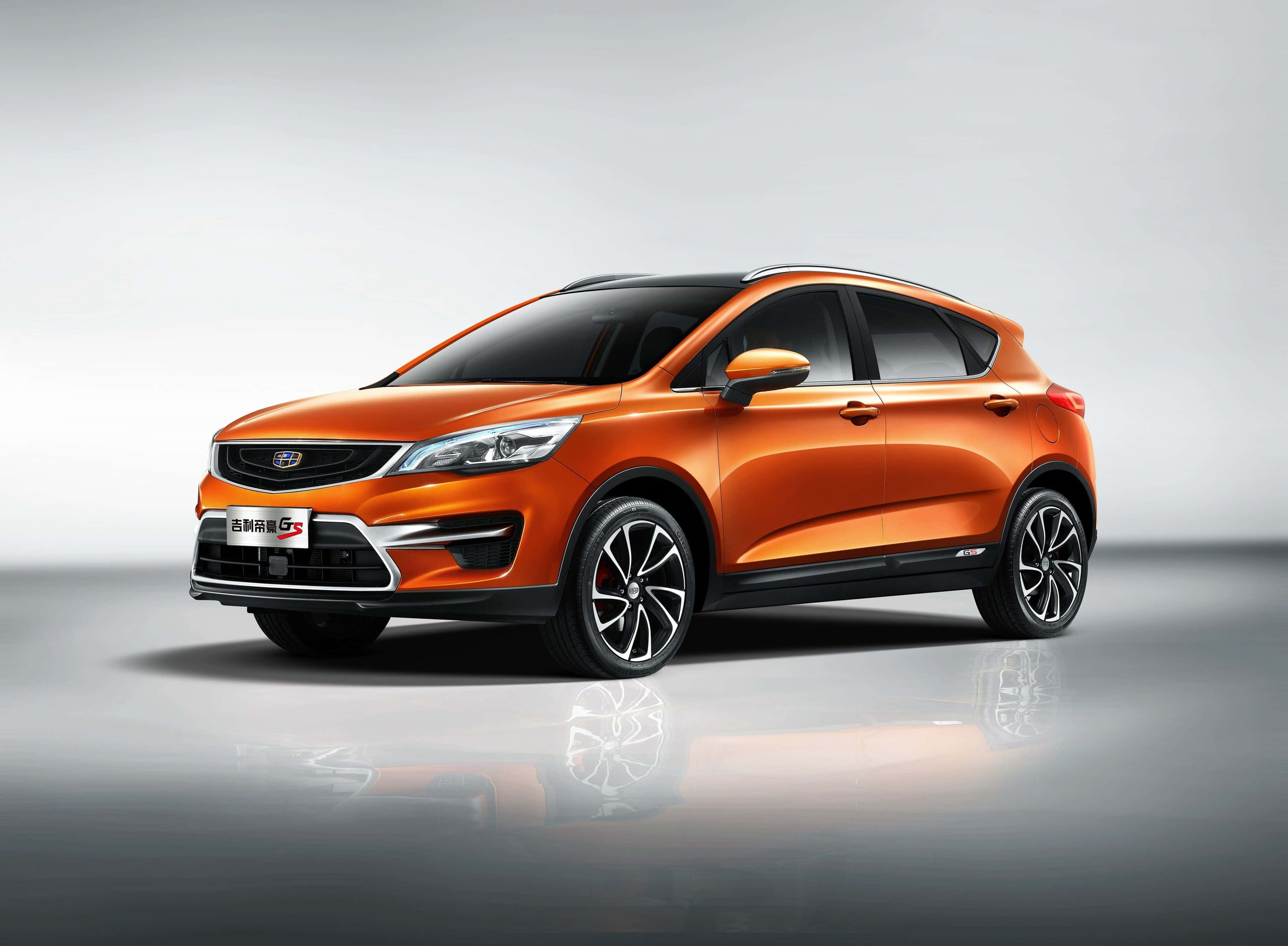 Geely 桌布 壁紙 — 一輛充滿活力的橙色緊湊型SUV，帶有黑色飾邊和時尚合金輪圈，在帶有反射地板的時尚工作室環境中展示。