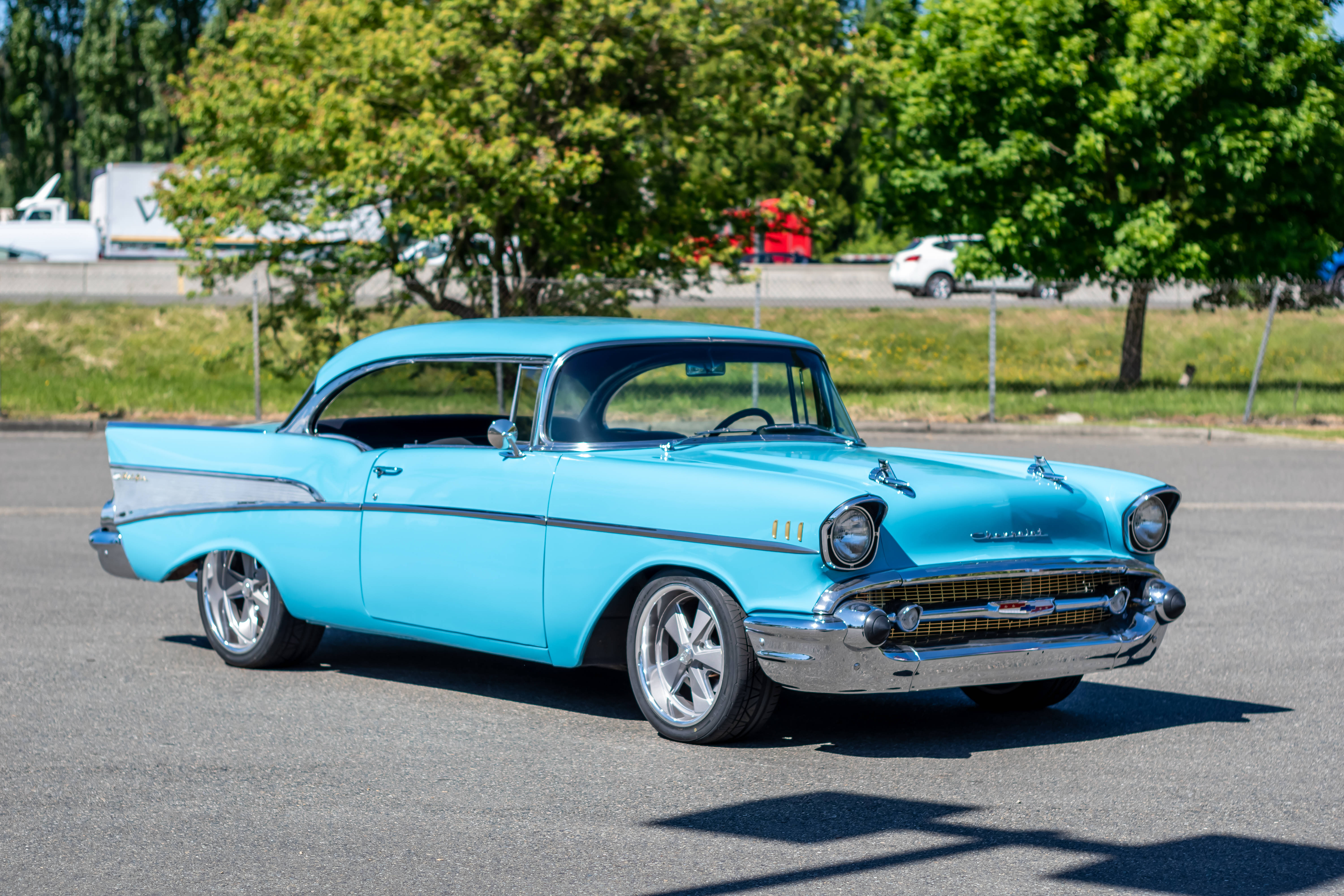 Chevrolet 桌布 壁紙 — 一輛充滿活力的淺藍色經典雪佛蘭Bel Air，帶有鍍鉻裝飾，停在陽光普照的瀝青路上。