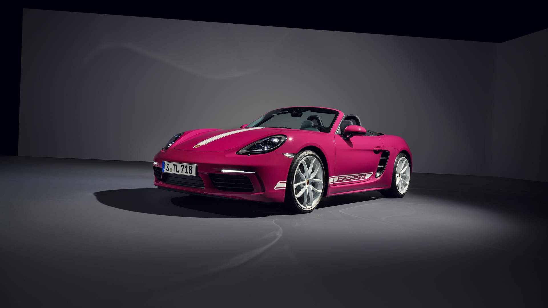 粉紅色保時捷 Boxster 敞篷車在黑暗的工作室中，聚光燈照射。 — 保時捷 GIF 壁紙