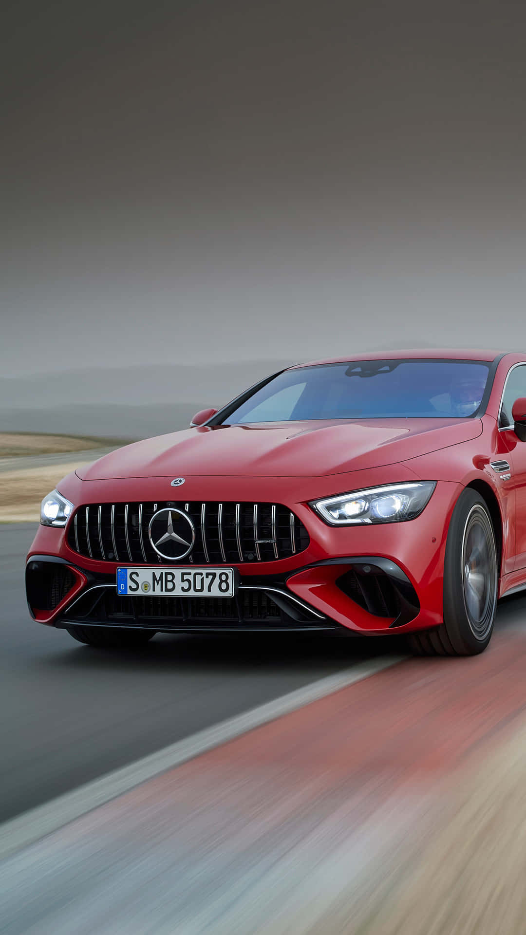 跑車 桌布 壁紙 — 一輛充滿活力的紅色 Mercedes-AMG GT R 在模糊的道路上奔馳，動態模糊效果強調了其動力和流線型設計。