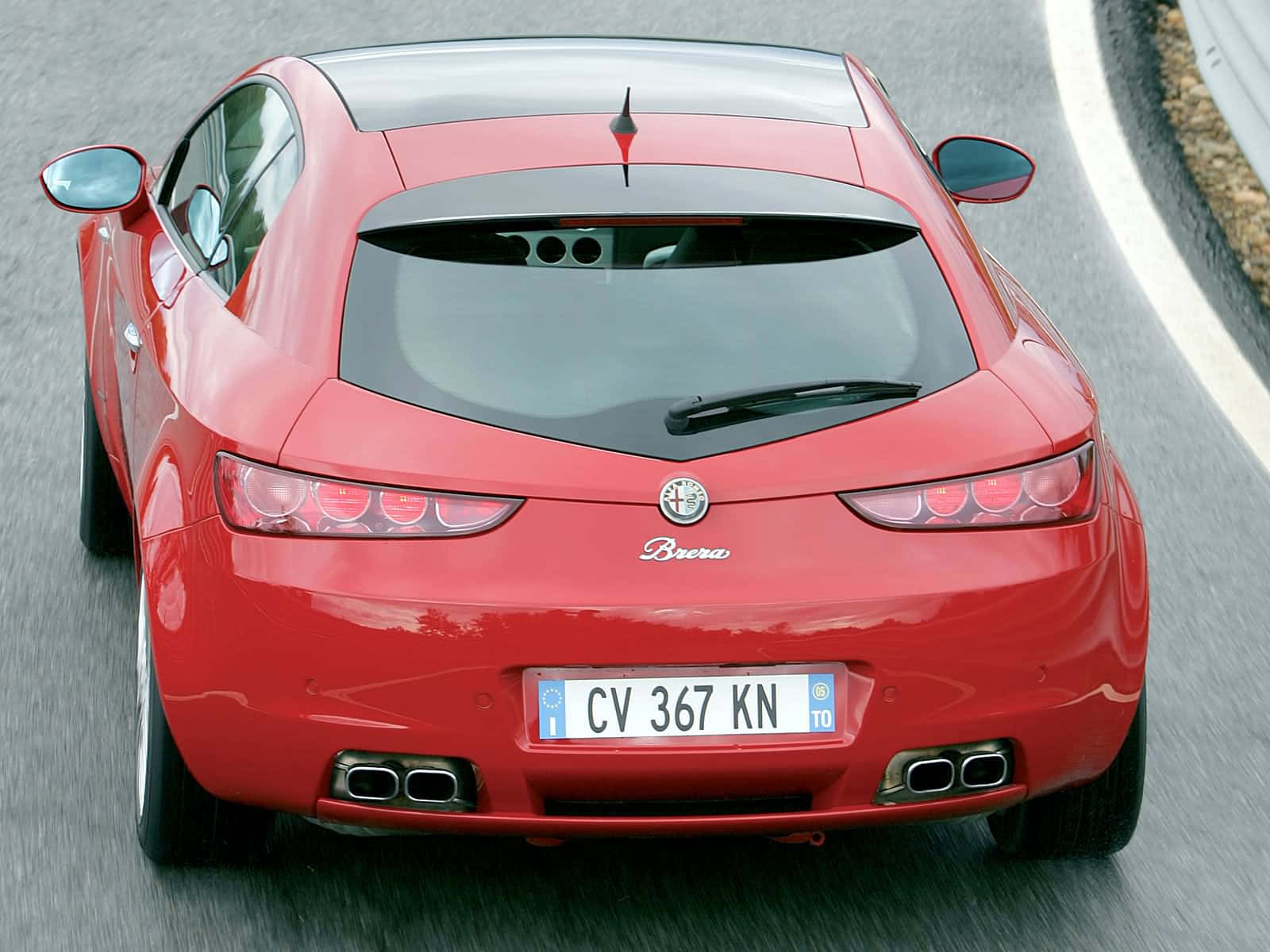 Alfa Romeo Brera 桌布 壁紙 — 一輛充滿活力的紅色愛快羅密歐 Brera 跑車，伴隨著動態模糊，沿著蜿蜒的瀝青道路巡航。