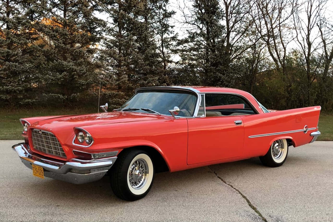 Chrysler 桌布 壁紙 — 一輛充滿活力的紅色經典汽車，帶有鍍鉻裝飾和白色輪胎，停在樹木環繞的車道上。