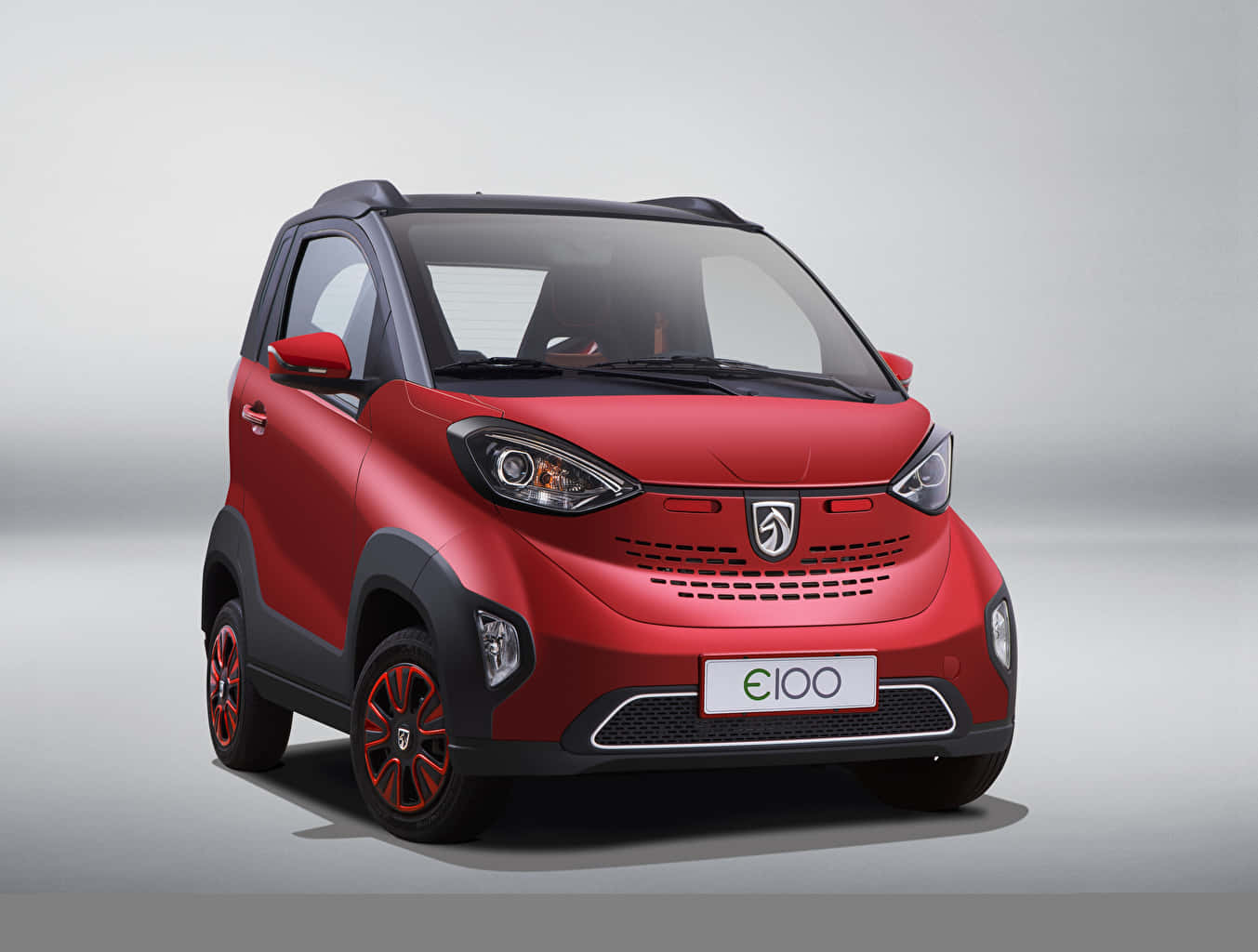 Baojun 桌布 壁紙 — 一輛充滿活力的紅色緊湊型電動車，帶有黑色飾邊和時尚合金輪轂，在中性工作室背景下擺拍。