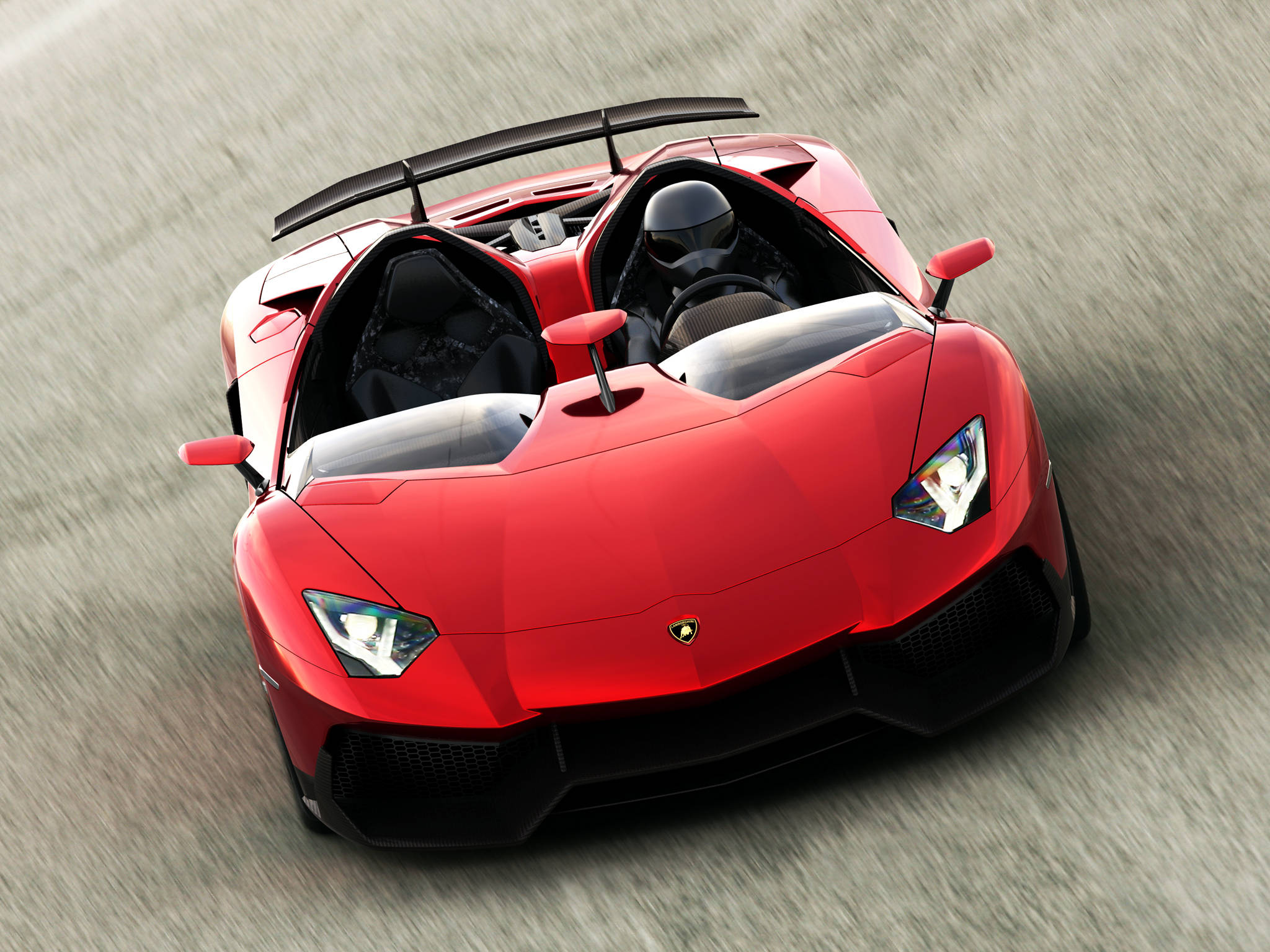 4K 藍寶堅尼 桌布 壁紙 — 一輛充滿活力的紅色藍寶堅尼 Aventador SVJ 敞篷跑車在賽道上奔馳，動態模糊效果突顯其高性能。