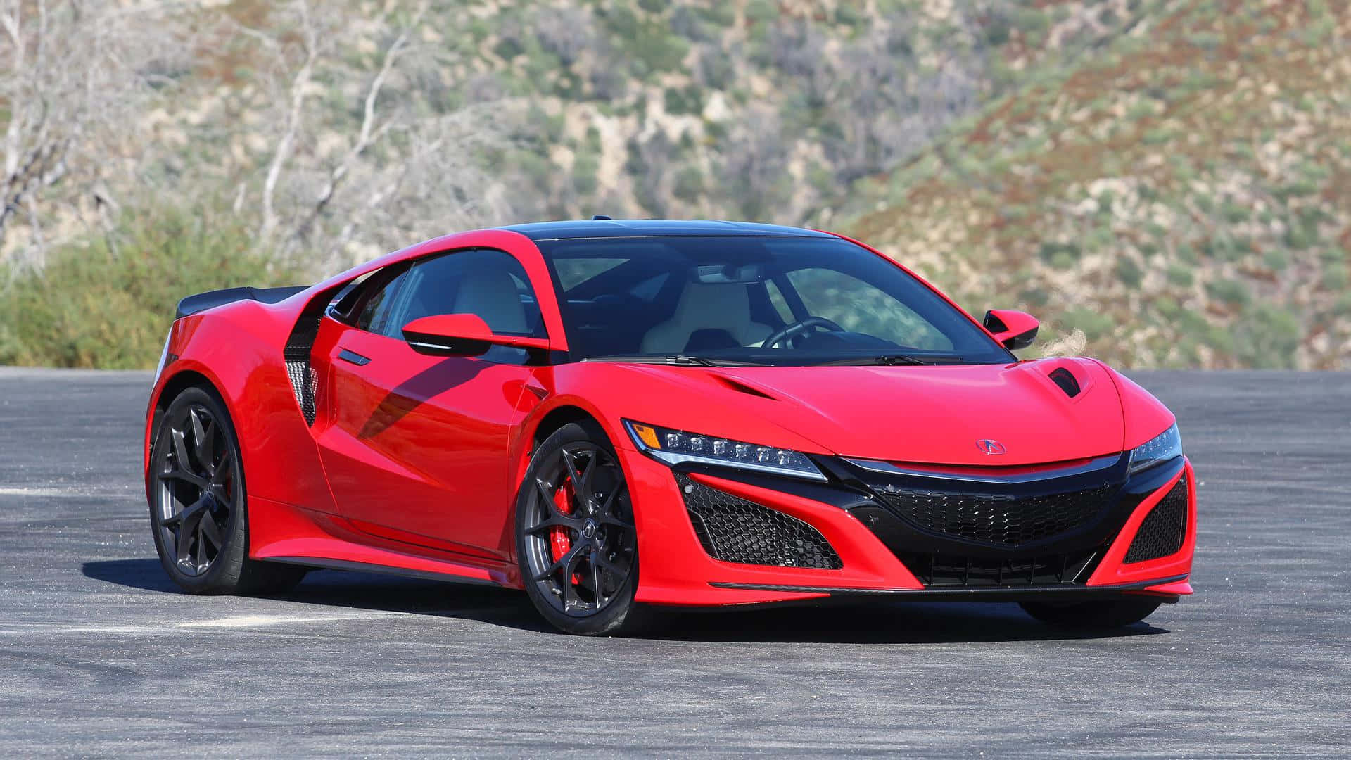 Acura 桌布 壁紙 — 一輛充滿活力的紅色跑車，帶有黑色飾邊，停在瀝青路面上，背景是乾燥的山坡。