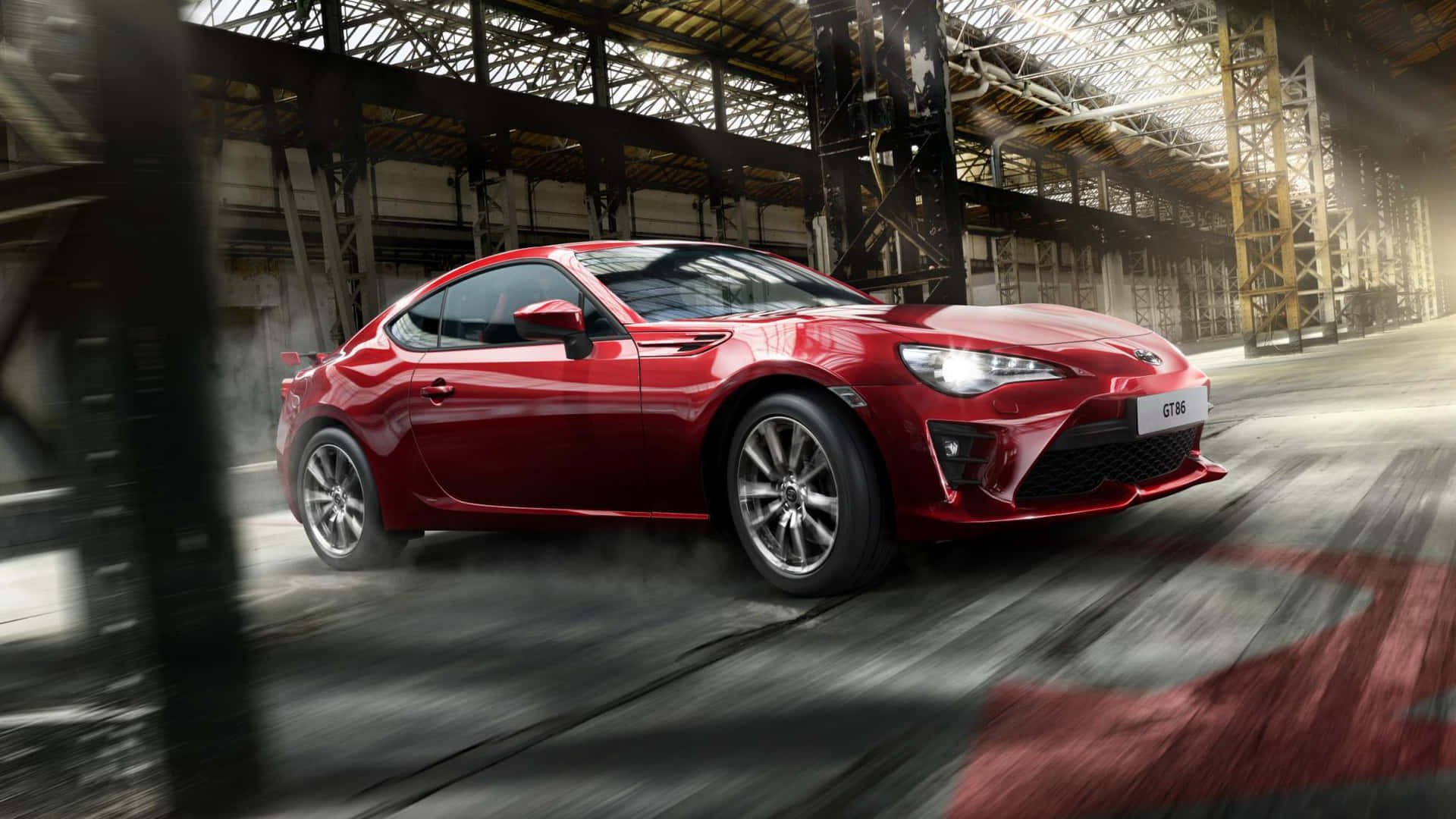 紅色跑車在工業倉庫中疾馳，帶有動態模糊。 — Toyota Supra Mk4 壁紙