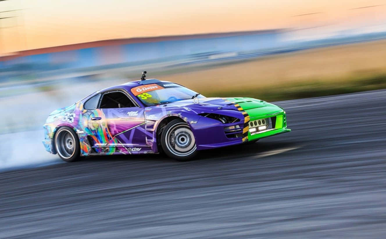 Supra 桌布 壁紙 — 一輛充滿活力的紫色和綠色甩尾車在日落時分的賽車場上冒煙輪胎，背景有動態模糊。