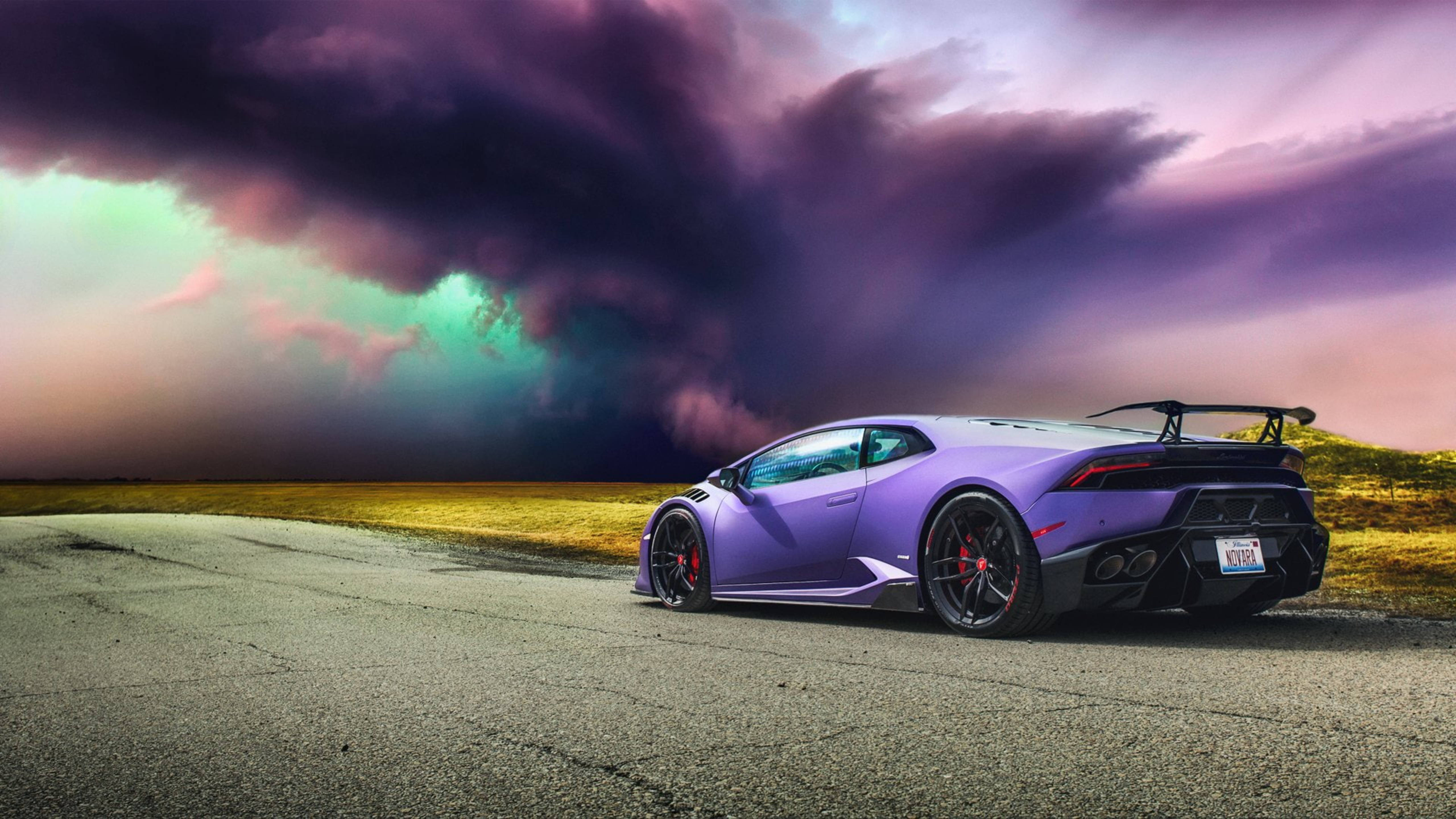 跑車 桌布 壁紙 — 一輛充滿活力的紫色藍寶堅尼 Huracán Performante 停在破裂的柏油路上，背景是戲劇性的紫色和藍綠色暴風雨天空。