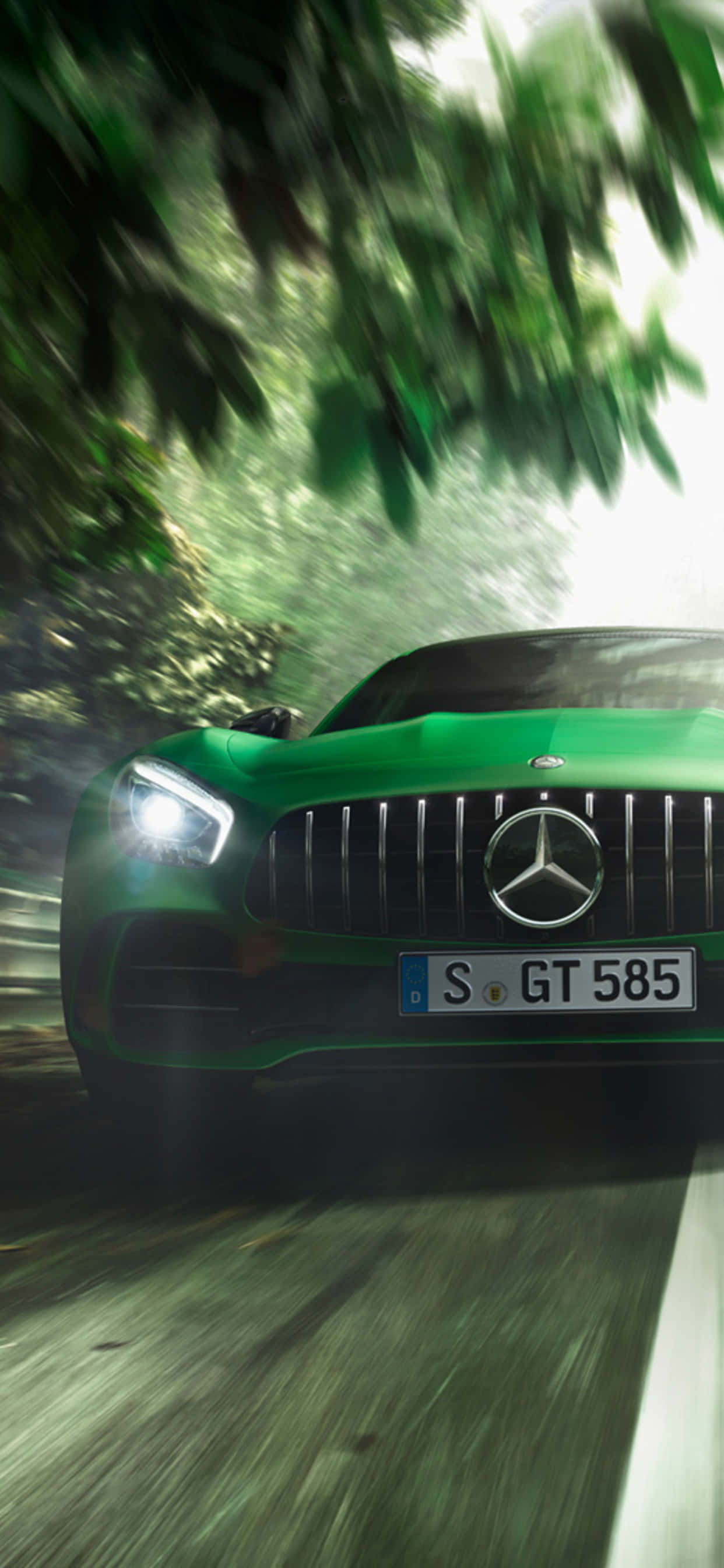 電玩遊戲 桌布 壁紙 — 一輛充滿活力的綠色 Mercedes-AMG GT 在茂密的森林中飛馳，樹葉和道路呈現動態模糊效果。