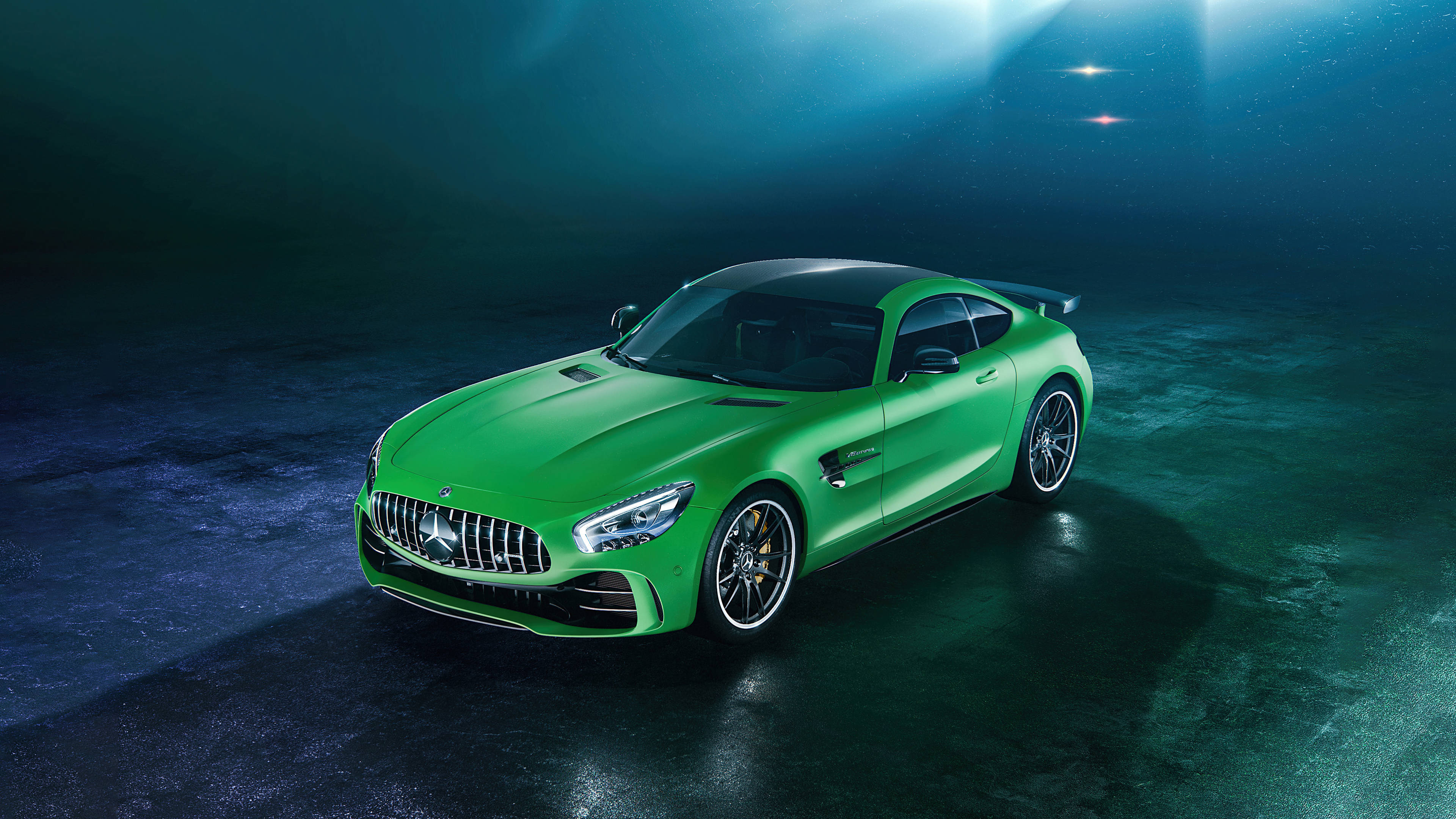 Gtr 桌布 壁紙 — 一輛充滿活力的綠色 Mercedes-AMG GT 跑車在黑暗、充滿氛圍的攝影棚中，在戲劇性的藍色聚光燈下閃閃發光。