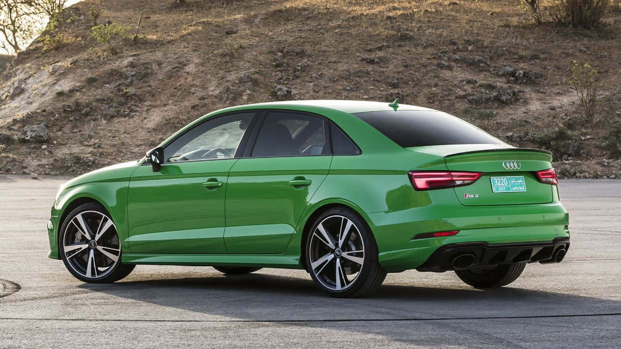 Sedan 桌布 壁紙 — 一輛充滿活力的綠色Audi房車停在柏油路上，背景是乾燥的山坡，在明亮的日光下。