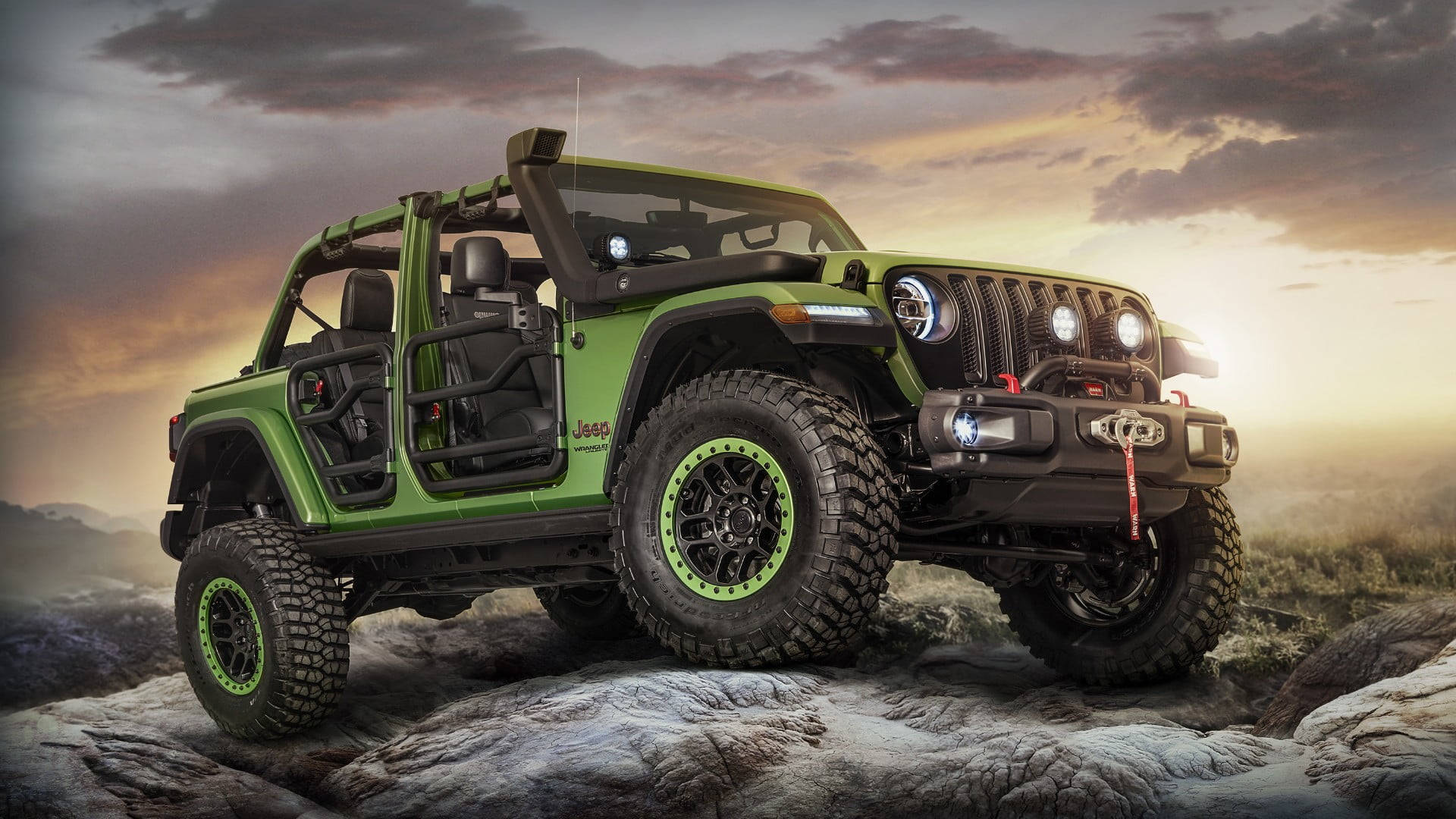 美學 桌布 壁紙 — 一輛充滿活力的綠色Jeep Wrangler，帶有黑色飾邊和超大輪胎，在戲劇性的日落天空下棲息在崎嶇的岩石上。