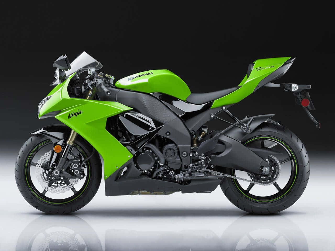 機車 桌布 壁紙 — 一輛充滿活力的綠色Kawasaki Ninja運動機車，帶有黑色點綴和鍍鉻細節，在黑暗背景下立於反射的攝影棚地板上。