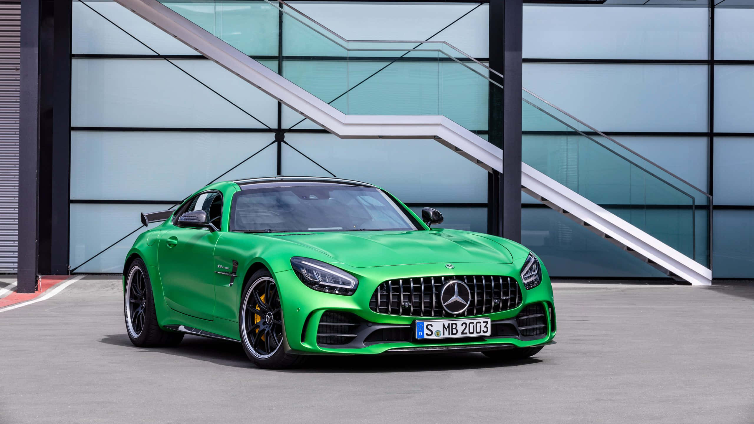 Amg Gt R 桌布 壁紙 — 一輛充滿活力的綠色Mercedes-AMG GT R跑車停在一棟帶有白色樓梯的現代玻璃建築前。