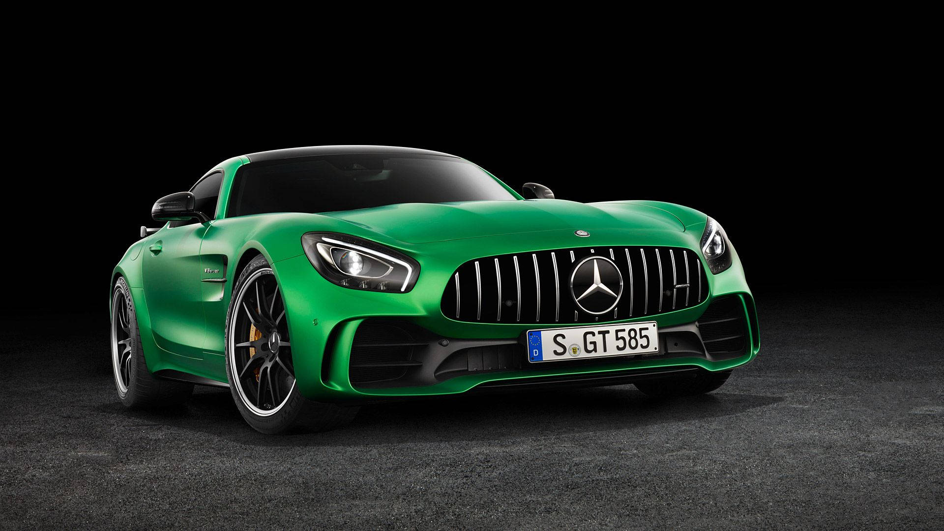 Mercedes Amg 桌布 壁紙 — 一輛充滿活力的綠色Mercedes-AMG GT S跑車在攝影棚燈光下閃閃發光，背景是純黑色。