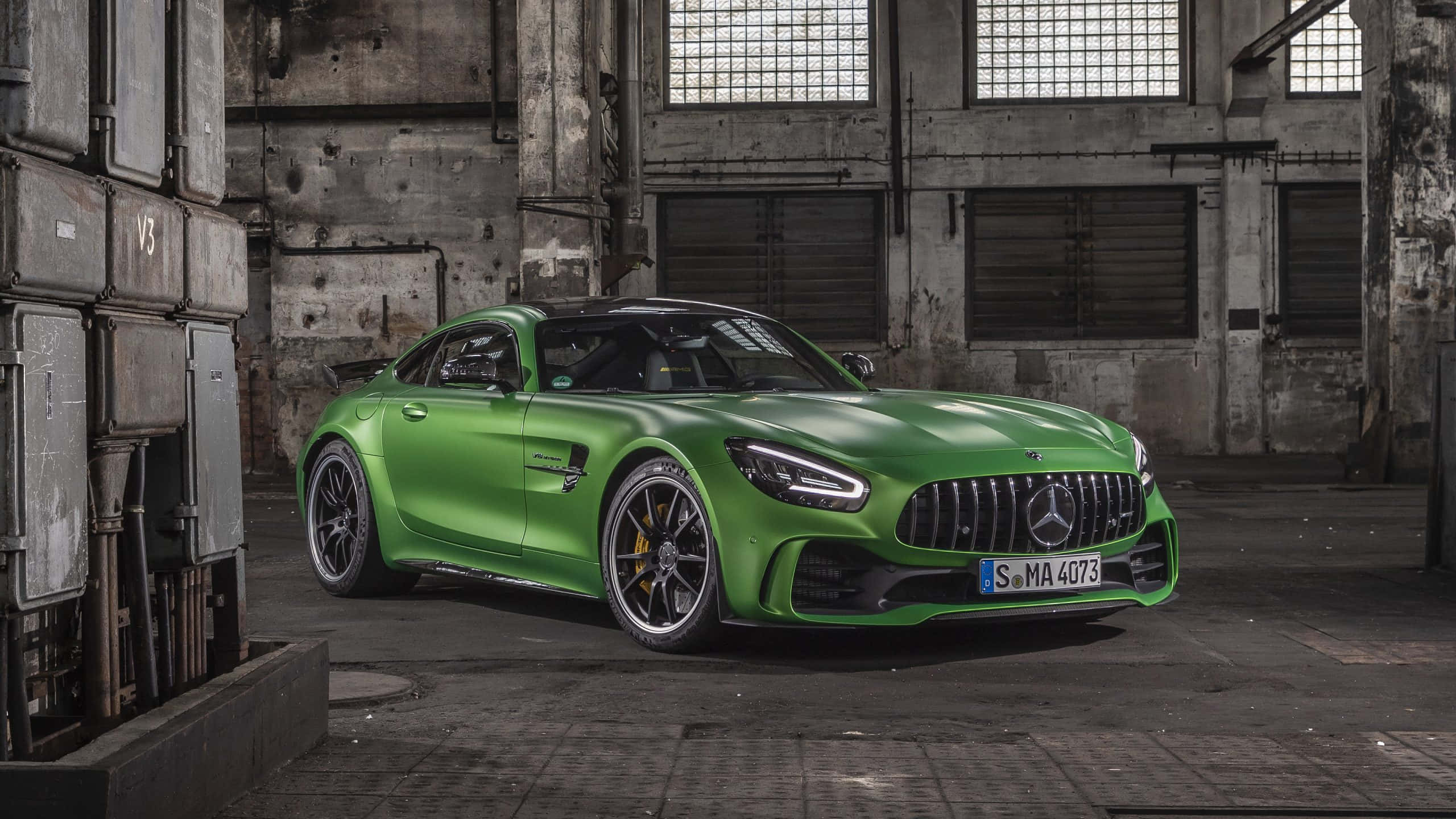 Mercedes 桌布 壁紙 — 一輛充滿活力的綠色Mercedes-AMG GT R跑車在風化的混凝土倉庫內，於工業照明下閃閃發光。