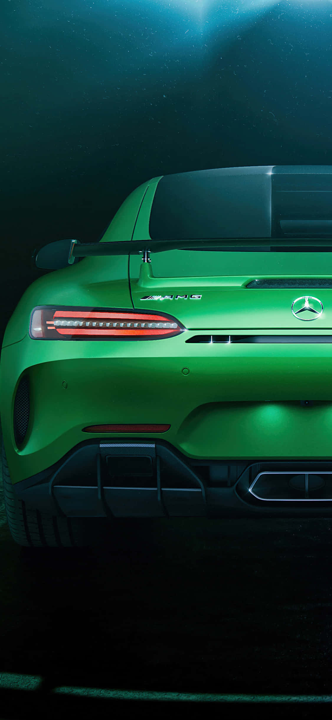 iPhone X Amg Gt-r 桌布 壁紙 — 一輛充滿活力的綠色Mercedes-AMG跑車尾部在戲劇性的水下燈光下閃耀著紅色尾燈。