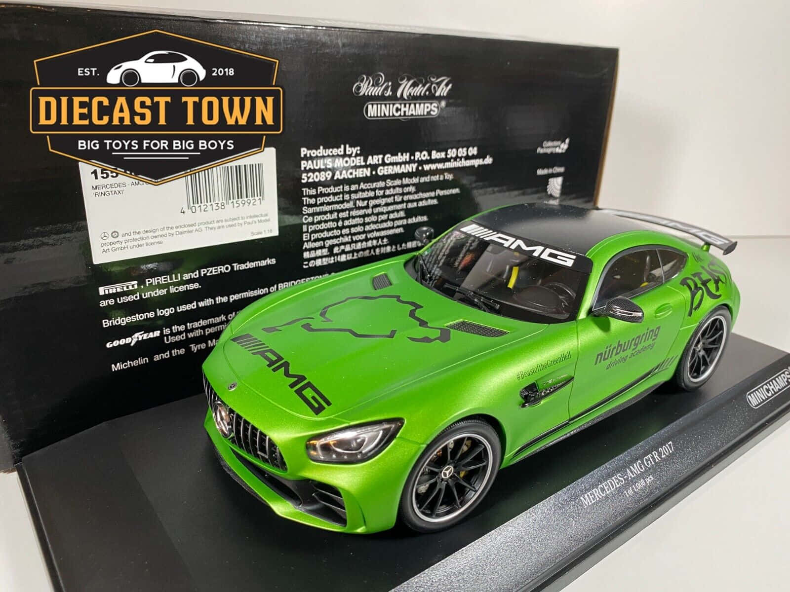 汽車 桌布 壁紙 — 一輛充滿活力的綠色壓鑄梅賽德斯-AMG GT R 2017模型車，展示在其帶有詳細貼紙和賽車塗裝的黑色品牌盒上。