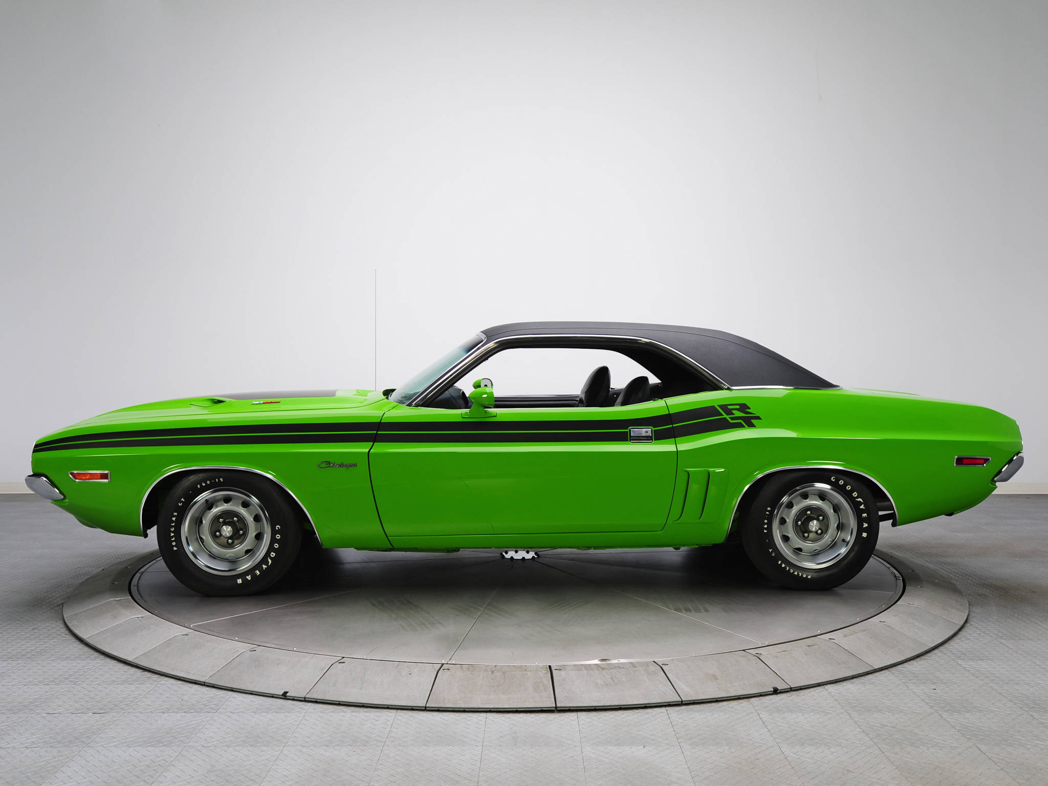 Challenger 桌布 壁紙 — 一輛充滿活力的綠色經典肌肉車，帶有黑色賽車條紋，停放在圓形轉盤上，背景是乾淨的白色工作室。