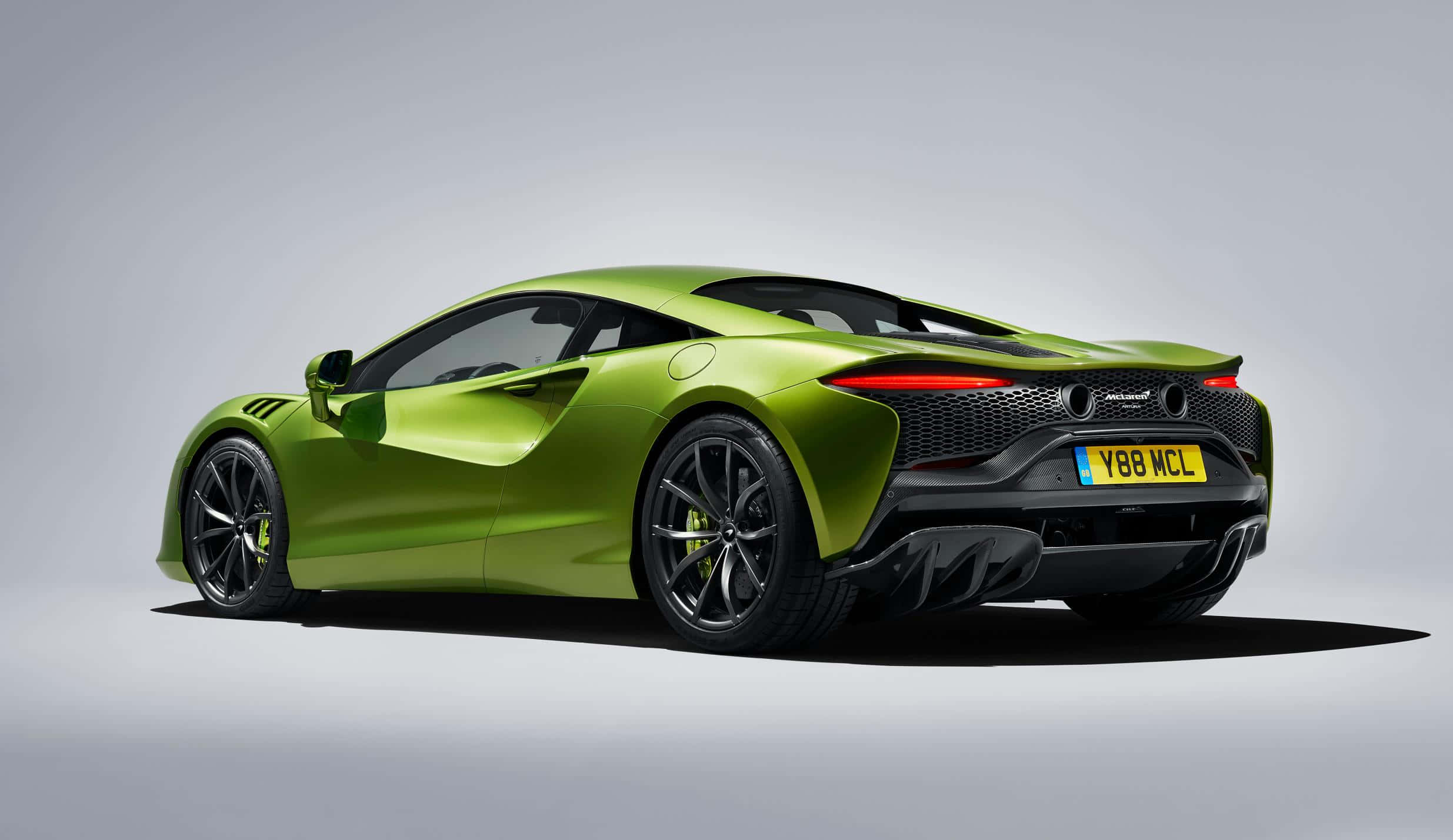 麥拉倫 桌布 壁紙 — 一輛充滿活力的萊姆綠色McLaren跑車，在攝影棚中以後方四分之三角度拍攝。