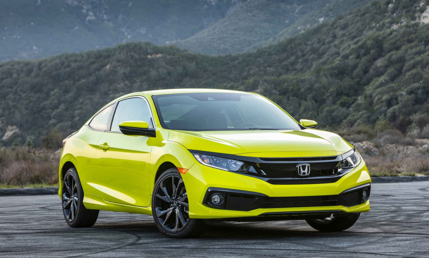 Honda Civic 桌布 壁紙 — 一輛充滿活力的萊姆綠色本田思域轎跑車停在柏油路上，背景是樹木繁茂的山丘。