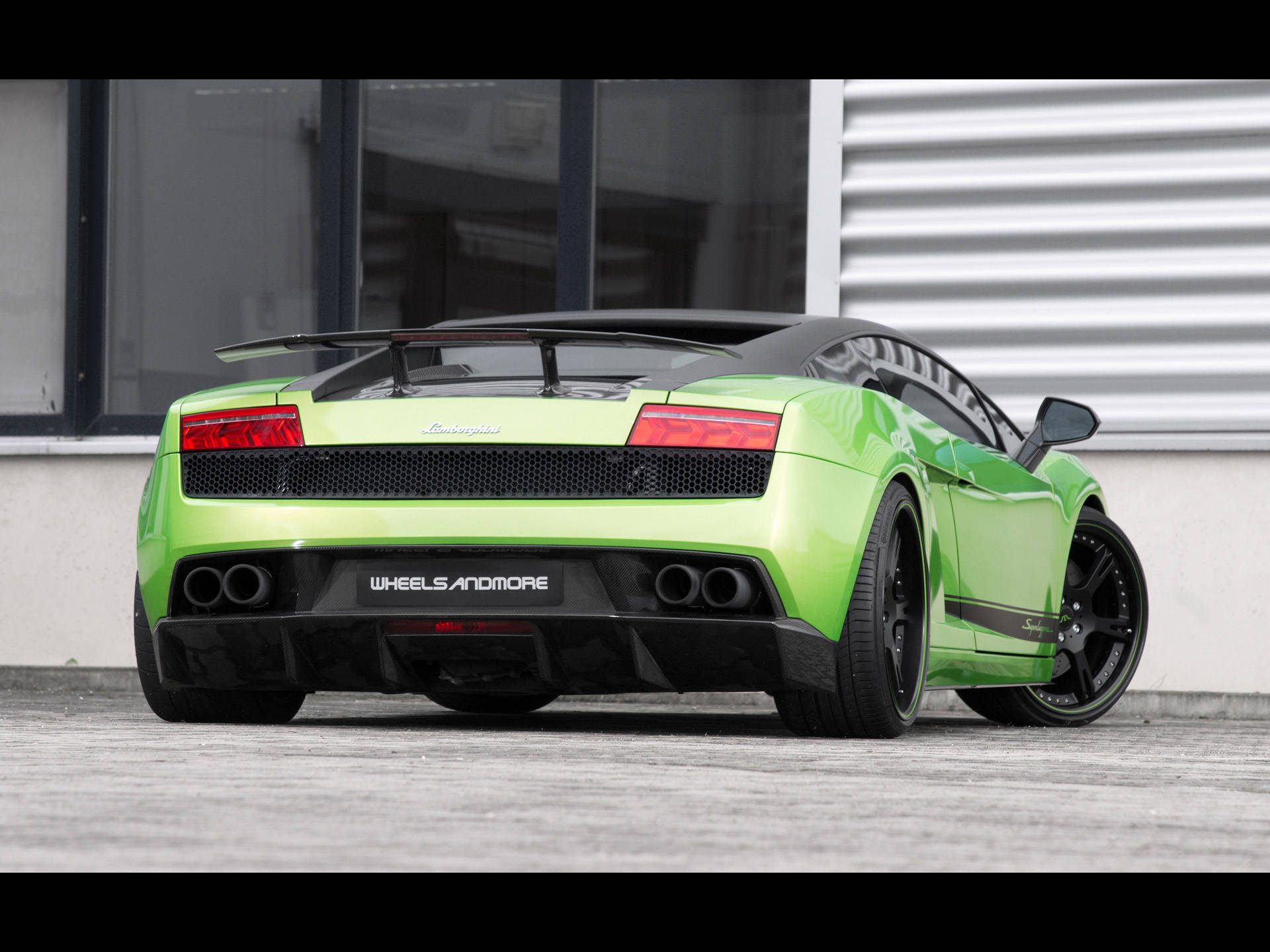 4K 藍寶堅尼 桌布 壁紙 — 一輛充滿活力的萊姆綠色藍寶堅尼Gallardo Spyder，帶有黑色飾件和四出排氣管，停放在現代建築前的混凝土上。