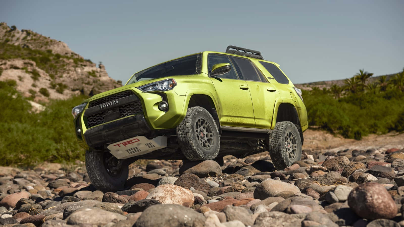 萊姆綠色豐田 4Runner TRD 在沙漠景觀中行駛在岩石上。 — Toyota Supra Mk4 壁紙