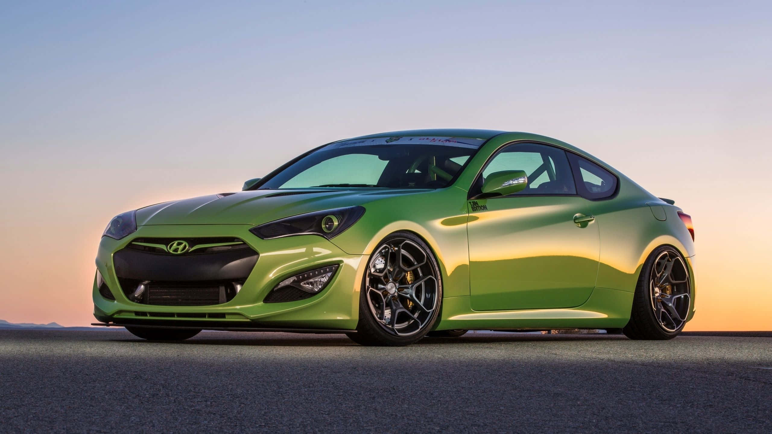 Hyundai Genesis 桌布 壁紙 — 一輛充滿活力的萊姆綠色跑車在柔和的日落天空下，在開闊的柏油路上閃閃發光。