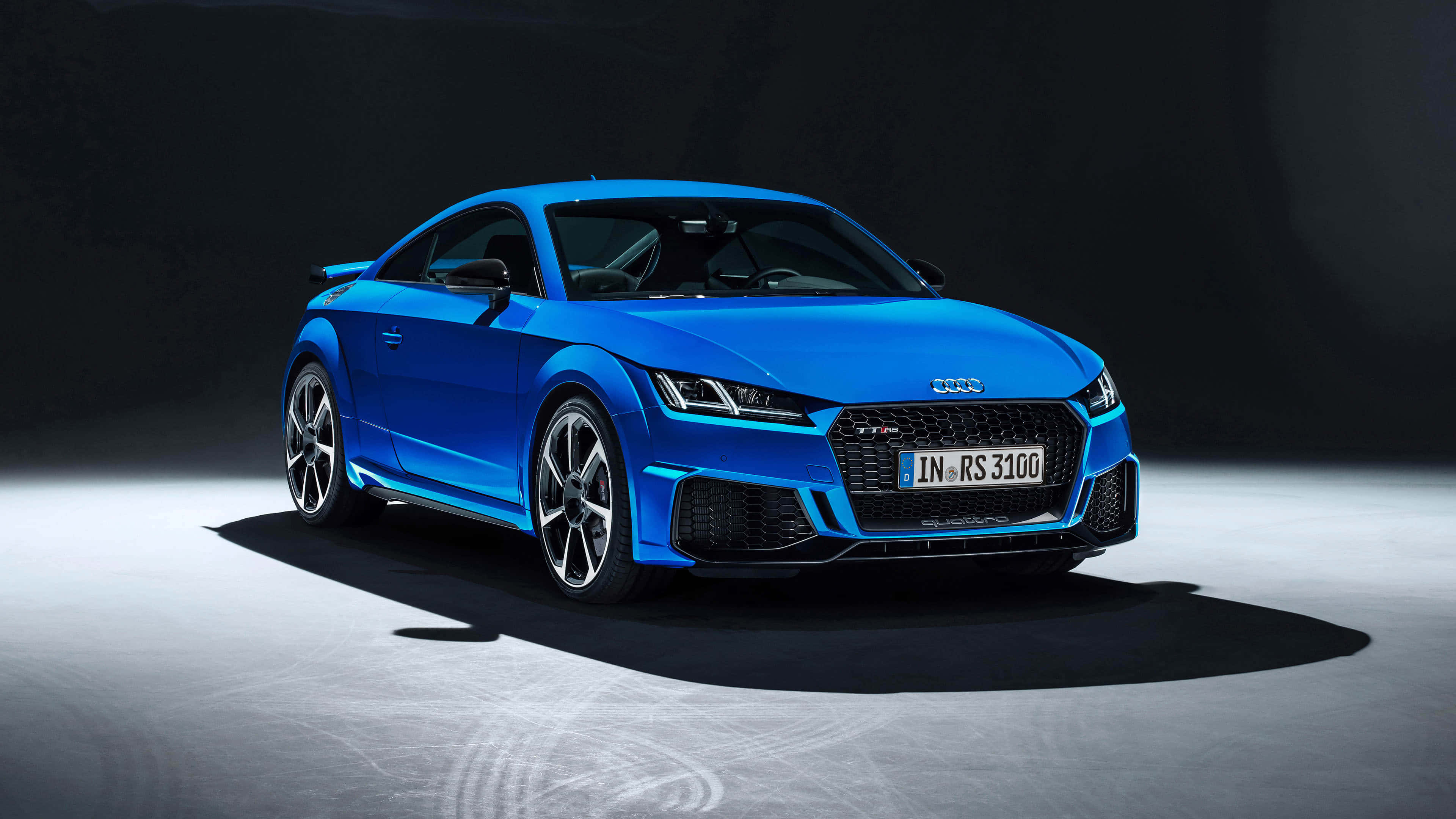Audi Tt Rs 桌布 壁紙 — 一輛充滿活力的藍色 Audi TT RS 3100 跑車在攝影棚燈光下，在極簡灰色地板上閃閃發光。