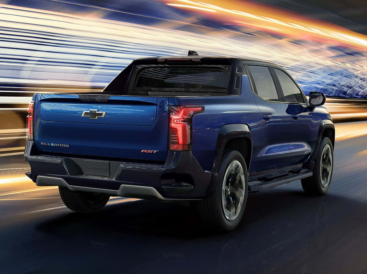 Chevrolet 桌布 壁紙 — 一輛充滿活力的藍色 Chevrolet Silverado RST 皮卡車向前飛馳，身後帶有橙色和藍色燈光的動態模糊條紋。