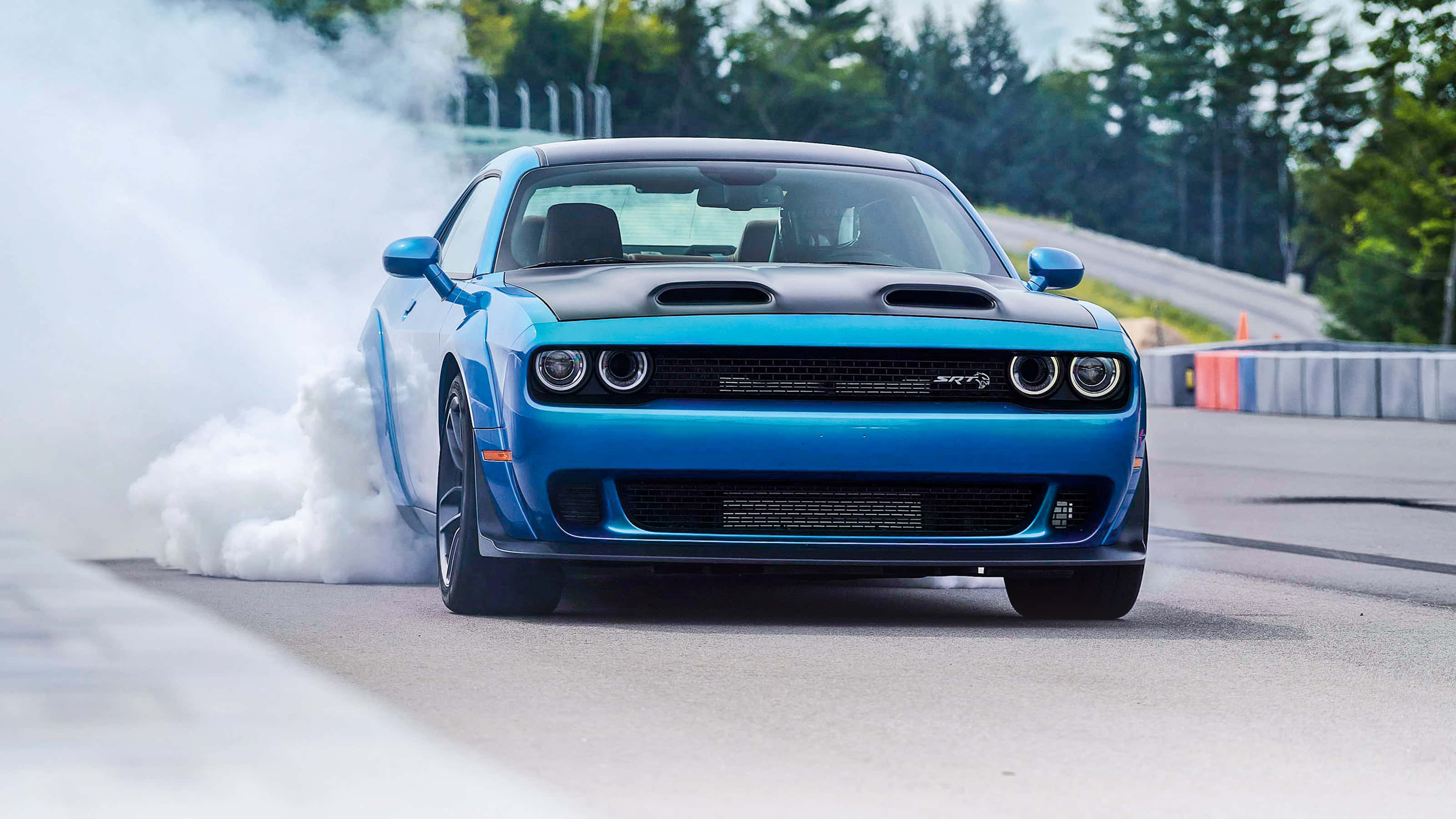 Dodge 桌布 壁紙 — 一輛充滿活力的藍色 Dodge Challenger 在賽車道上進行燒胎，從後輪胎冒出濃厚的白煙。
