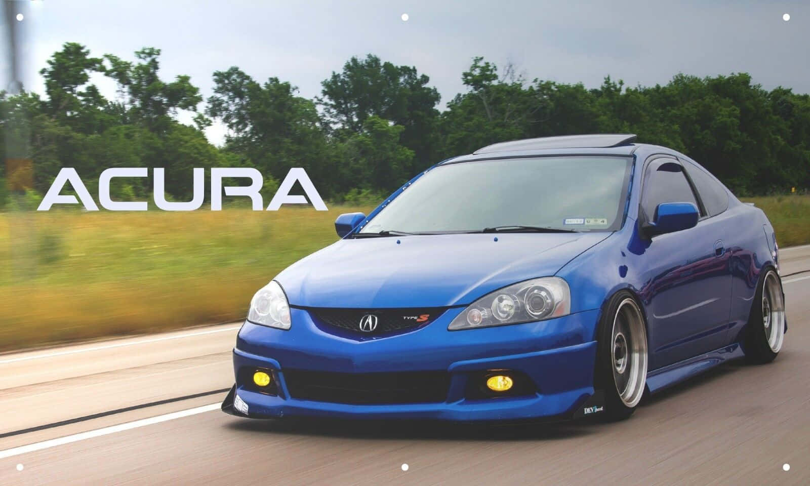 Acura Rsx 桌布 壁紙 — 一輛充滿活力的藍色Acura轎跑車在道路上疾馳，背景是模糊的綠色樹木和草地。