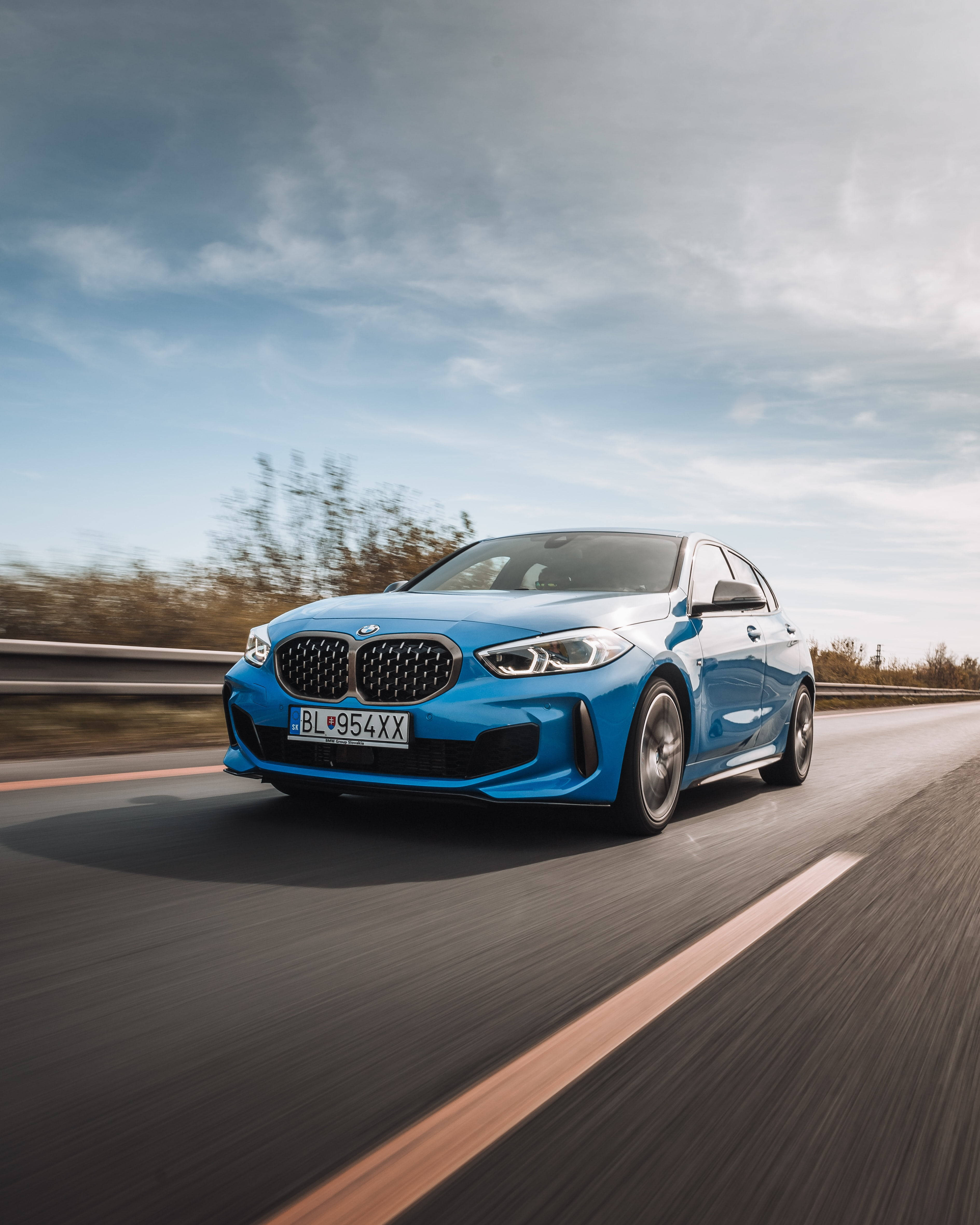 藍色BMW在秋樹和陰天的道路上疾馳。 — BMW 動圖 壁紙