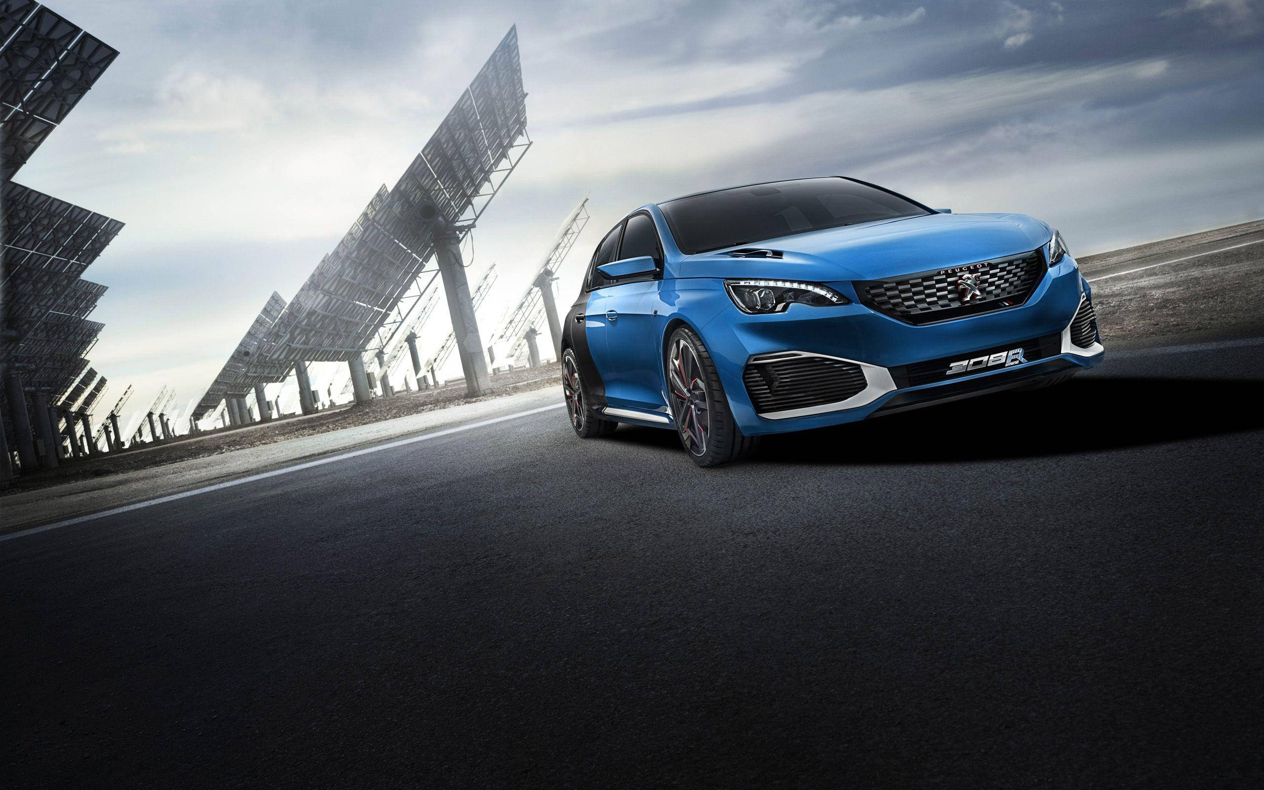 Peugeot 桌布 壁紙 — 一輛充滿活力的藍色Peugeot 308 GT停在黑暗的道路上，旁邊是高聳的太陽能板，天空多雲。