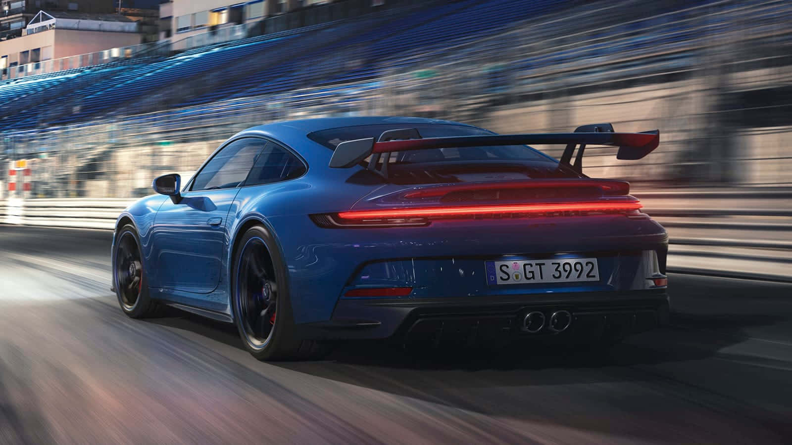 保時捷 桌布 壁紙 — 一輛充滿活力的藍色保時捷911 GT3 RS在賽道上疾馳，背景帶有動態模糊效果。