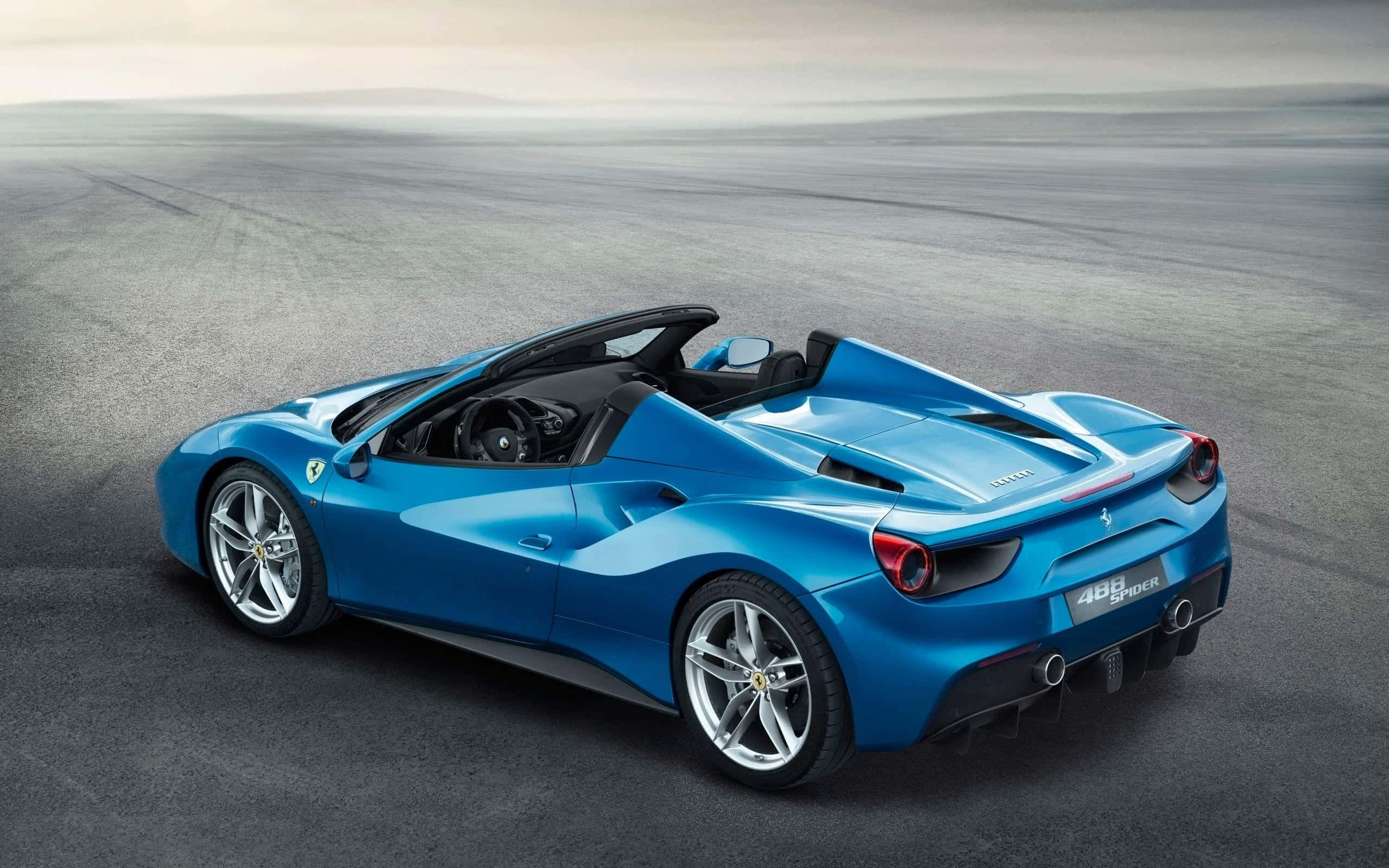 Ferrari 488 Spider 桌布 壁紙 — 一輛充滿活力的藍色法拉利488 Spider敞篷車在廣闊空曠的瀝青賽道上，在柔和日光下閃閃發光。