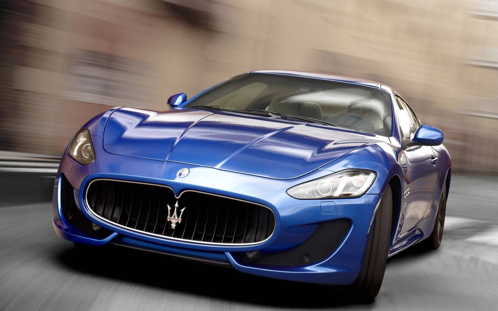 Maserati 桌布 壁紙 — 一輛充滿活力的藍色瑪莎拉蒂跑車向前飛馳，背景帶有動態模糊效果。
