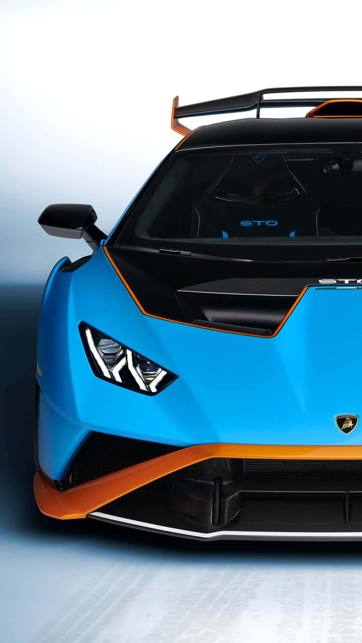Pixel 3xl Lamborghini 桌布 壁紙 — 一輛充滿活力的藍色藍寶堅尼STO，帶有橙色點綴和後尾翼，在漸變背景下的攝影棚拍攝。